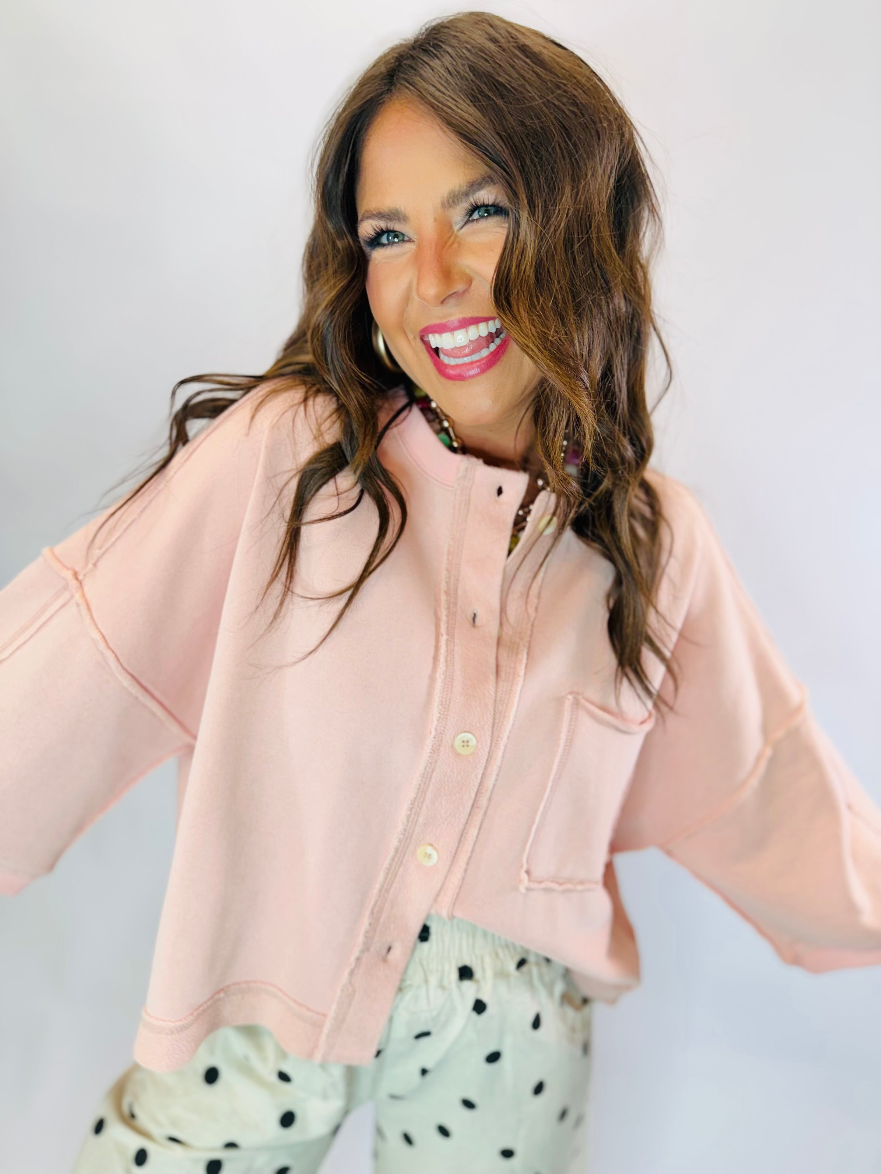 Woman wearing the Maggie Top, a light pink button-front cropped sweatshirt with chest pocket.
