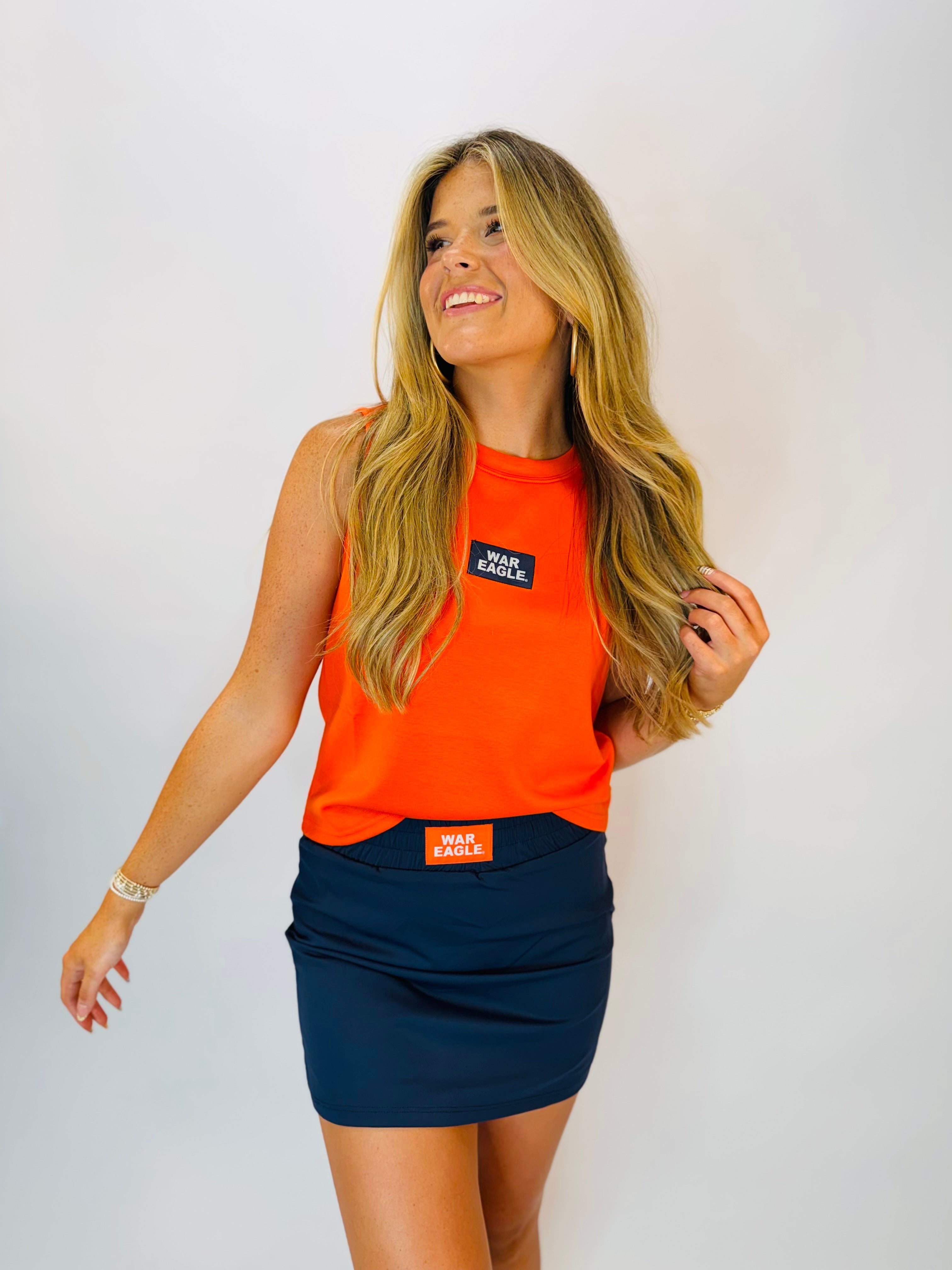 Navy blue high-waisted skort with orange "War Eagle" patch, paired with matching orange tank top.