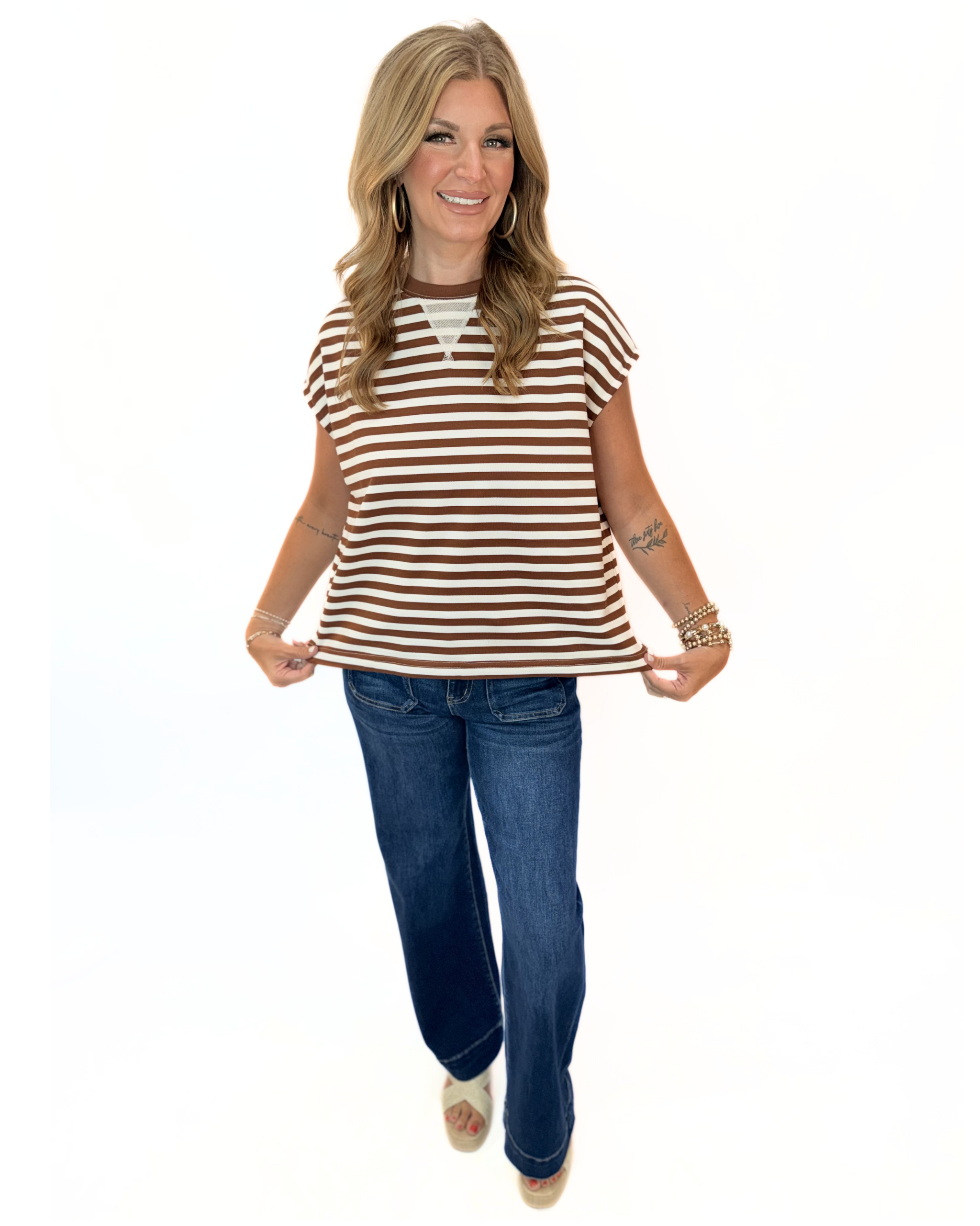 Warren Top in brown and white horizontal stripes with short sleeves, paired with wide-leg jeans.