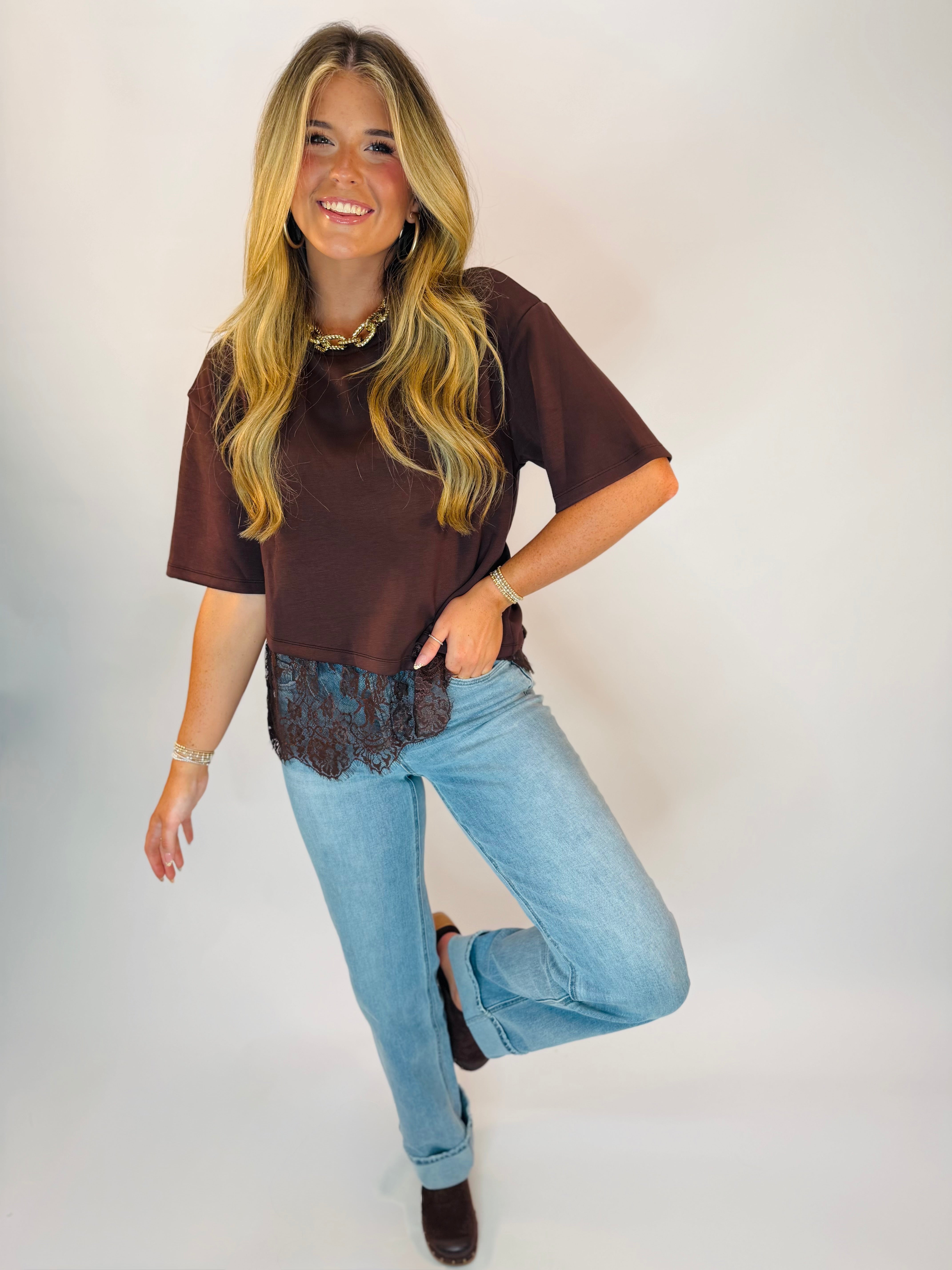 Brown cropped short-sleeve top with lace hem detail, styled with light wash jeans and brown boots.