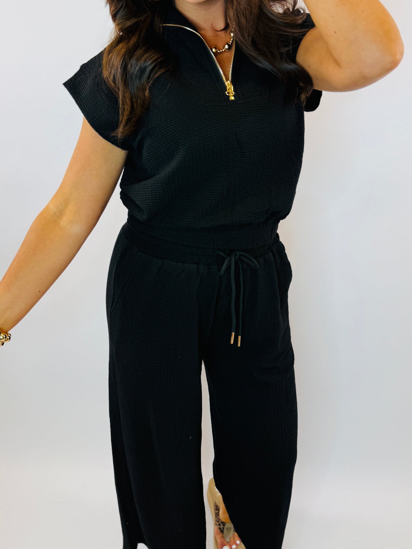Black ribbed short-sleeve top with quarter-zip neckline and matching drawstring pants set