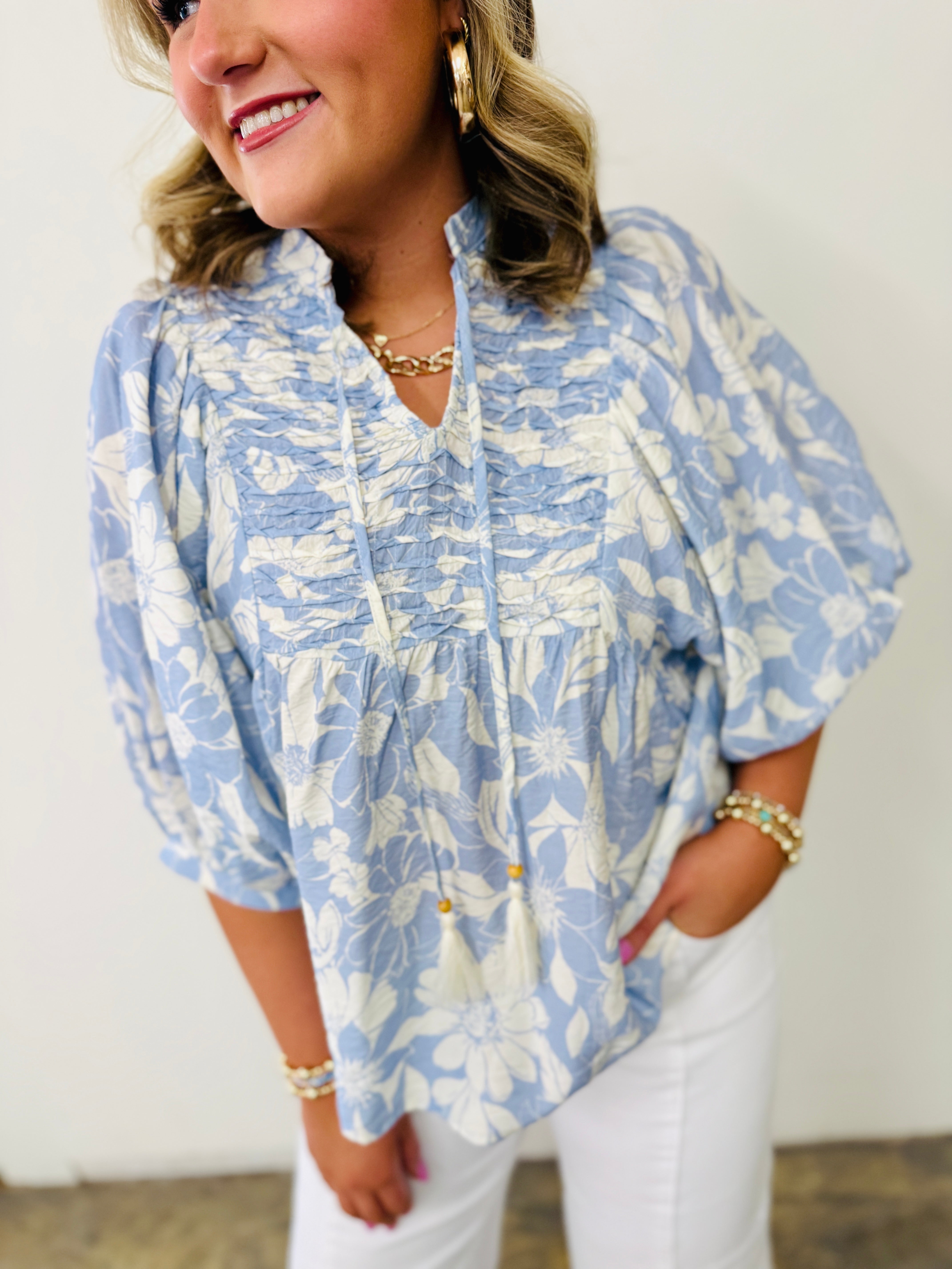 Woman wearing blue and white floral print Alaya Soft Top with gathered neckline and three-quarter sleeves
