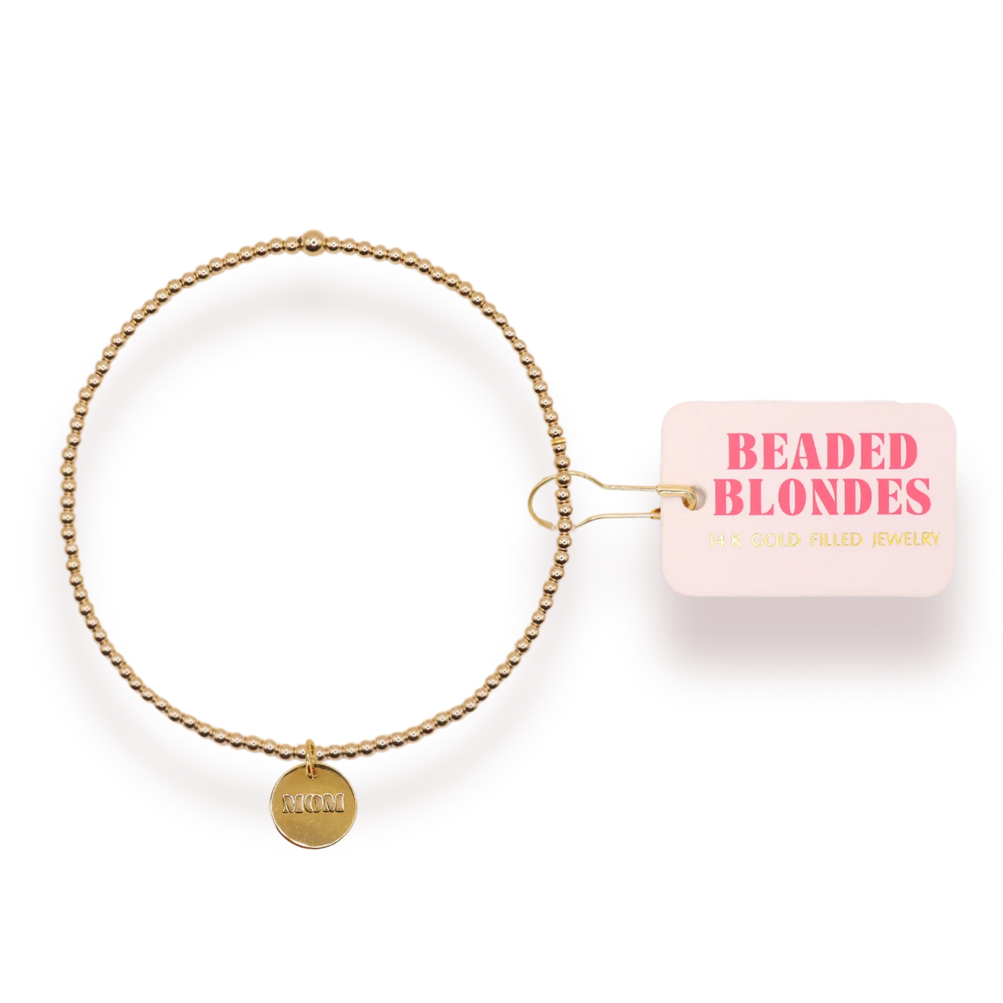 Gold beaded bracelet with "MOM" charm pendant and pink Beaded Blondes jewelry tag on transparent background