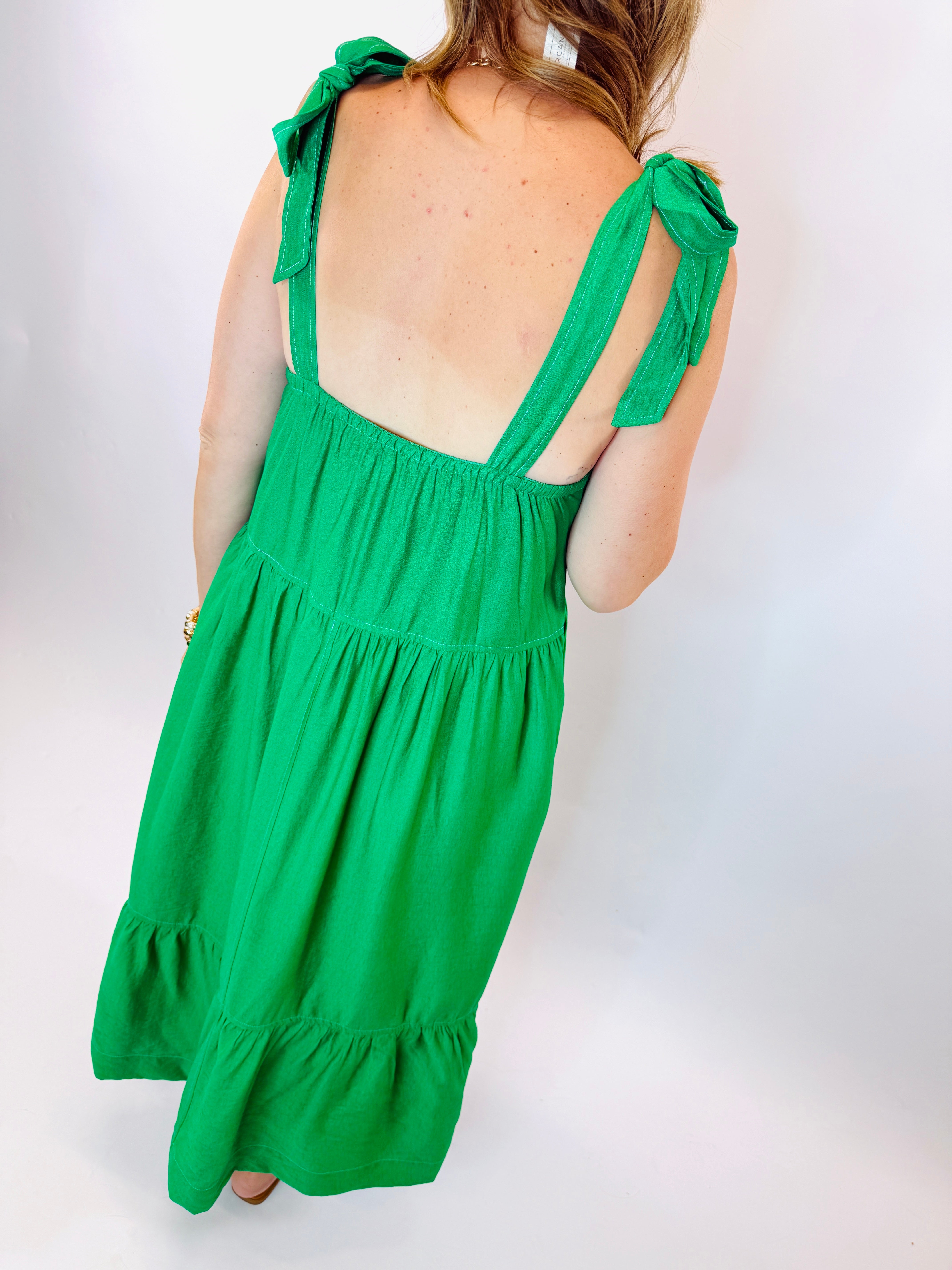 Green tiered maxi dress with open back and tie shoulder straps, shown from behind