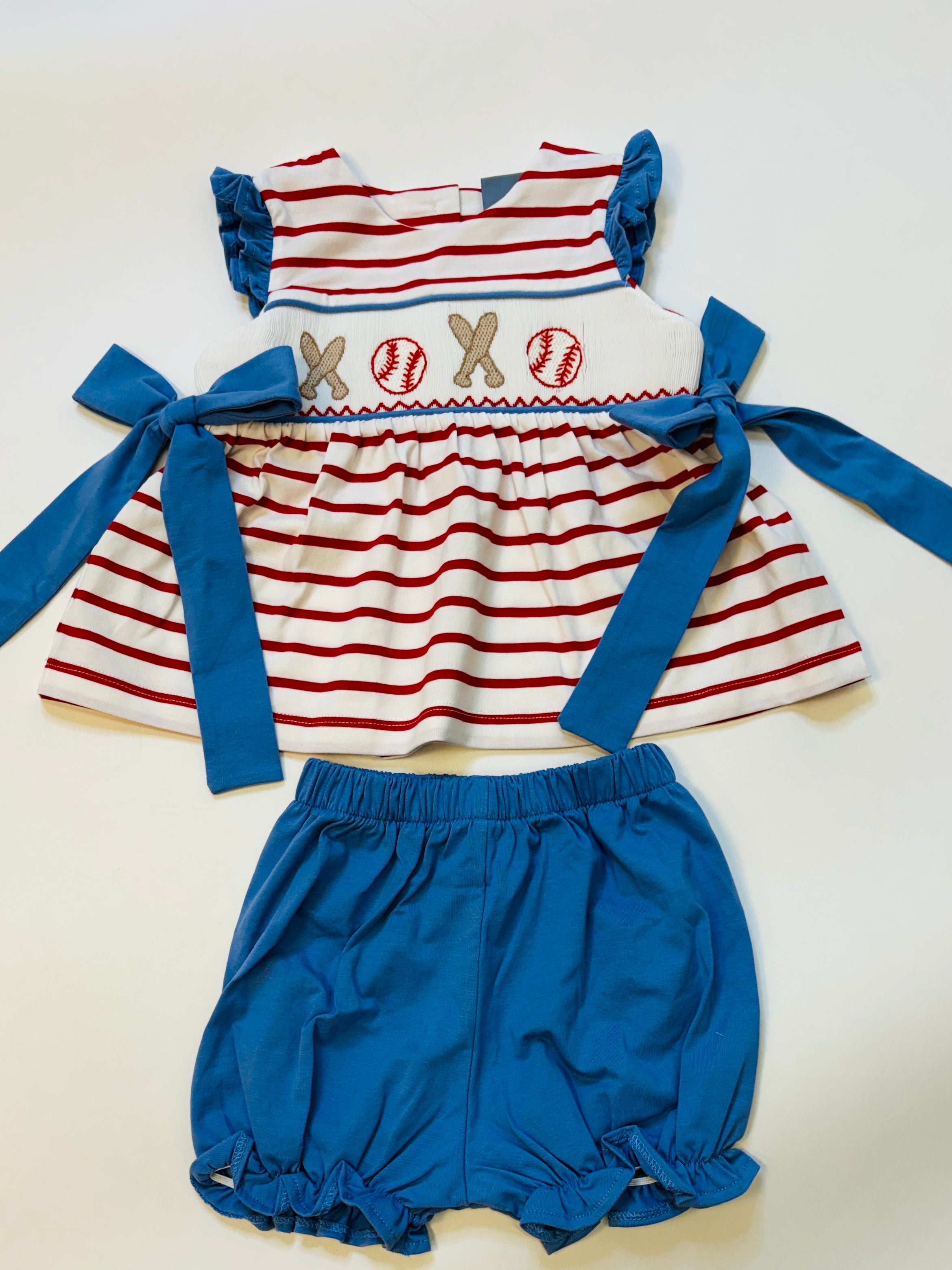 Baseball-themed baby outfit with red striped top featuring embroidered baseballs and bats, paired with blue bloomers.