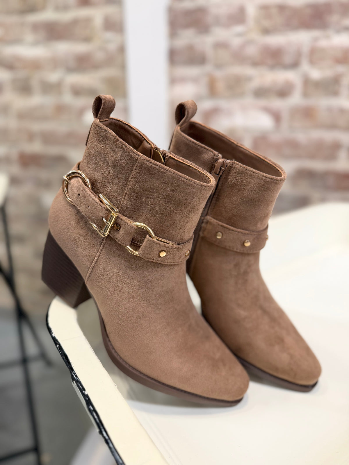 Deena Bootie in tan suede with gold buckle strap detail, block heel, and side zipper closure.