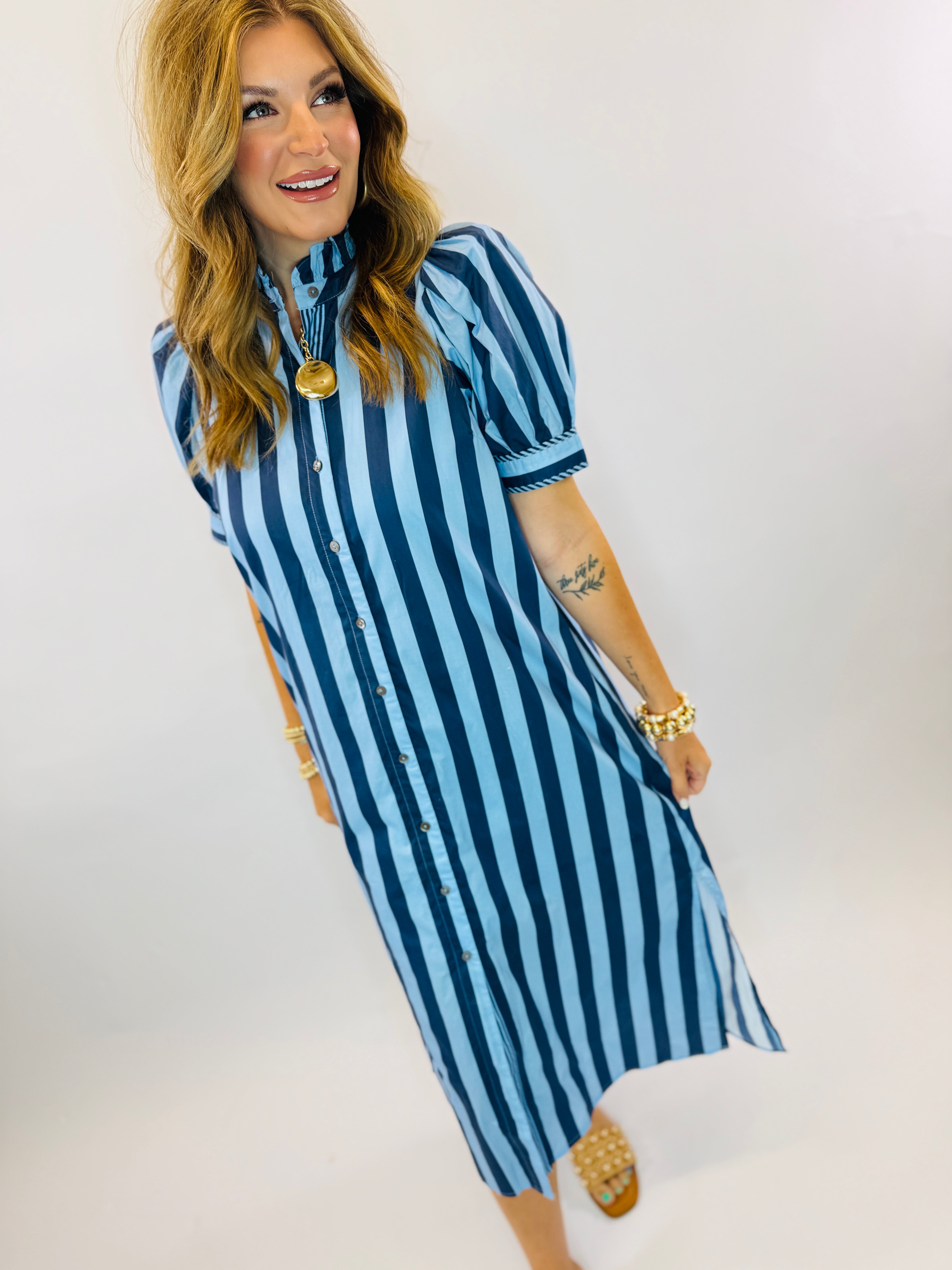 Woman wearing blue and white striped button-front maxi dress with short sleeves and collar