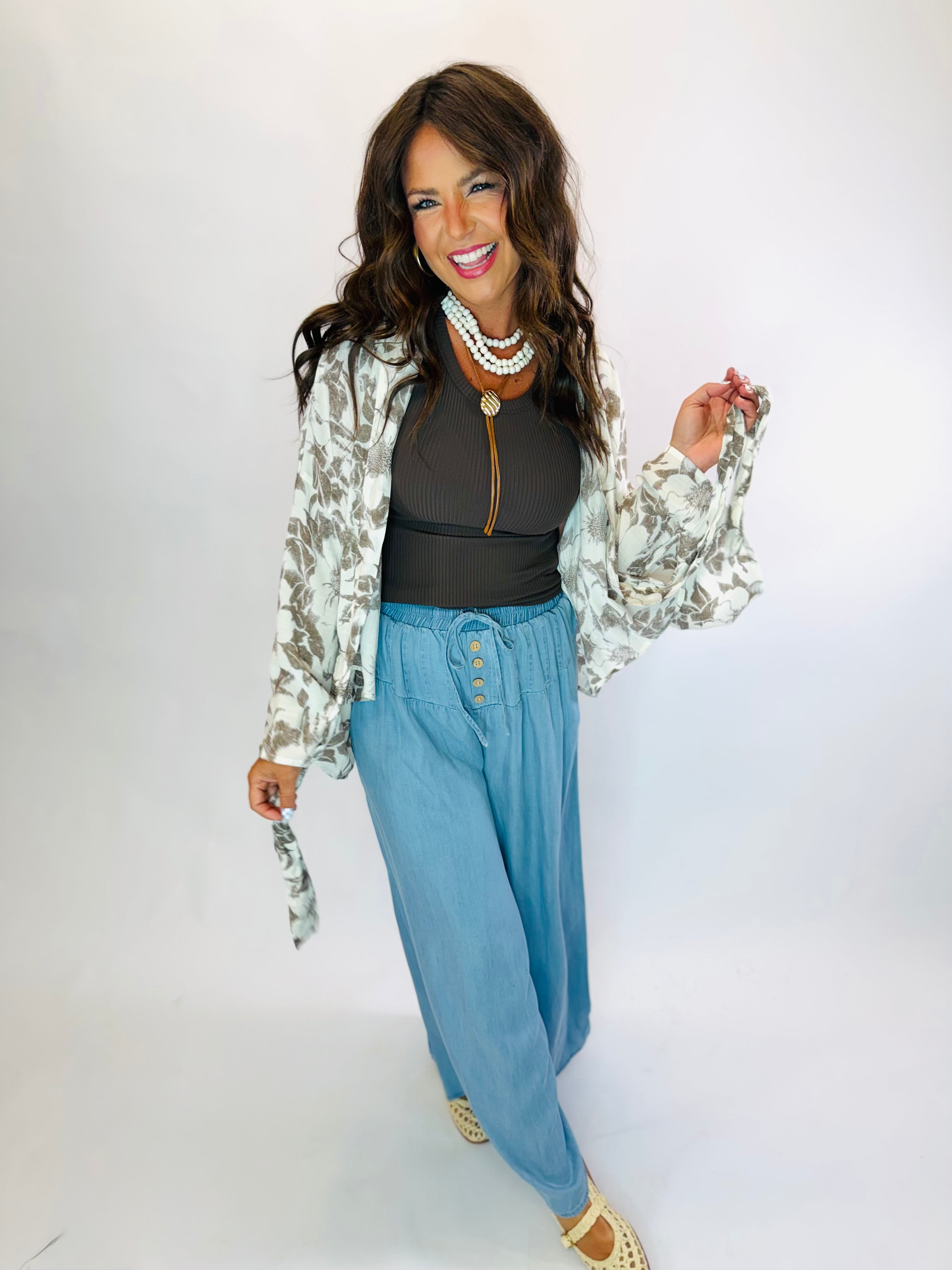 Light blue wide-leg drawstring Phoebe Pants with elastic waist and button detail, styled casually.