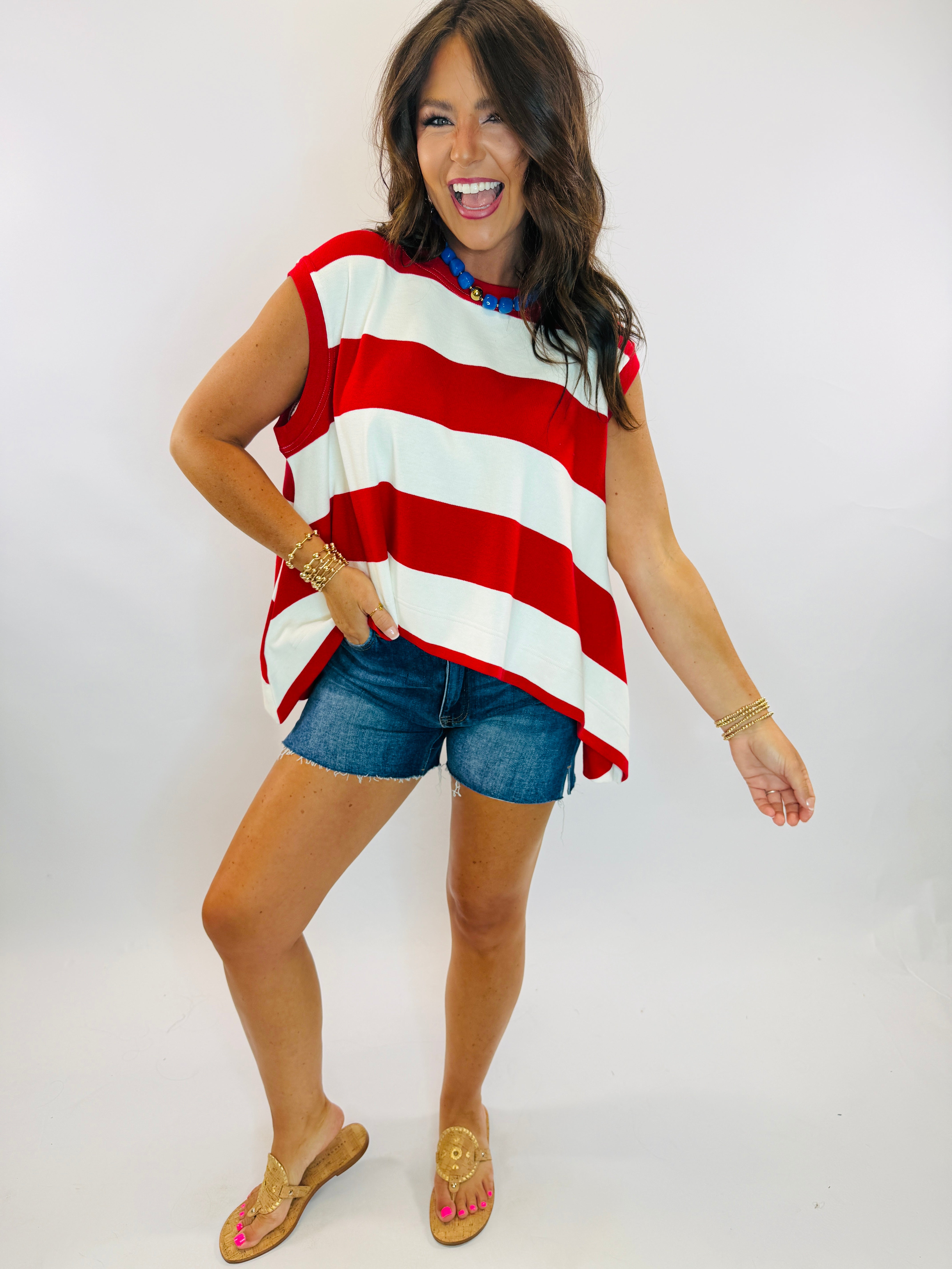 Kennedy Top sweatshirt in bold red and white horizontal stripes, sleeveless, oversized fit, styled with denim shorts.