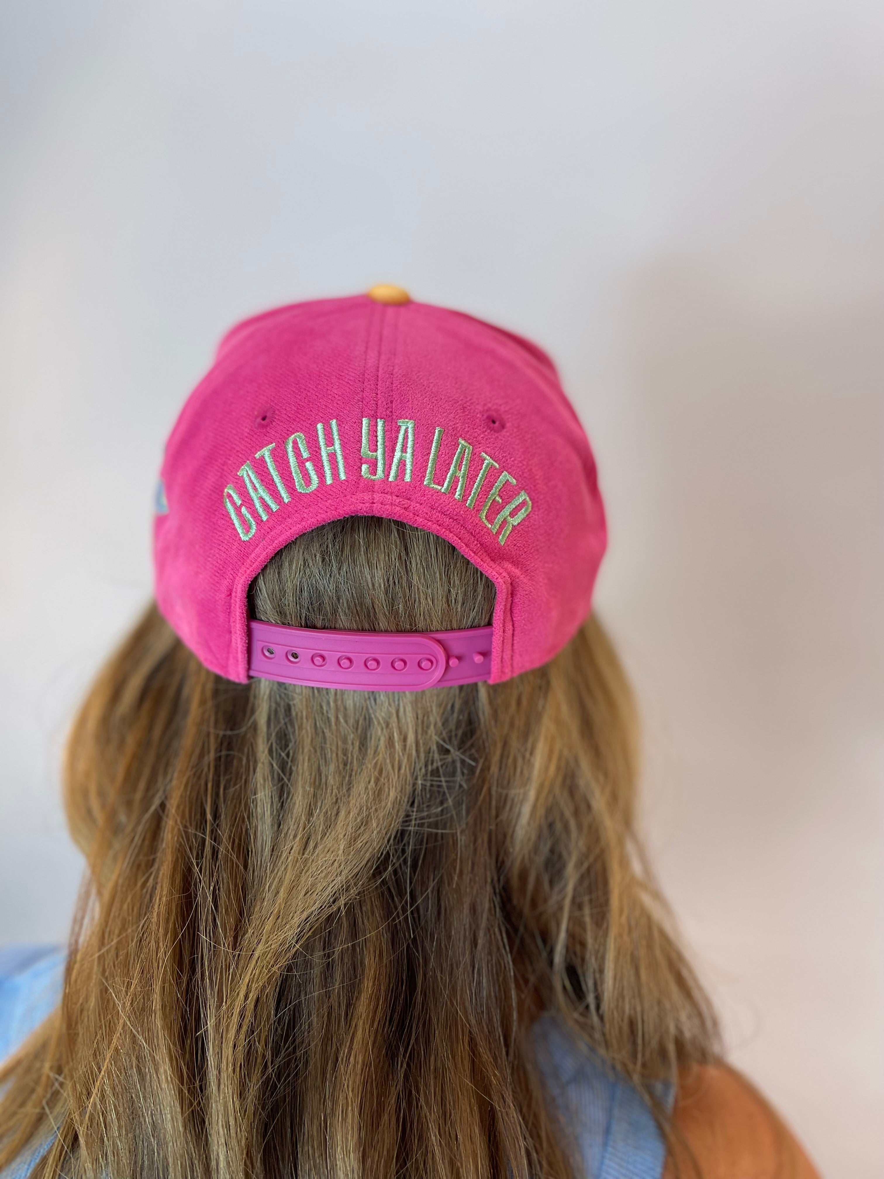Back view of pink "REEL-Y BUSY" snapback hat with green "CATCH YA LATER" embroidery.