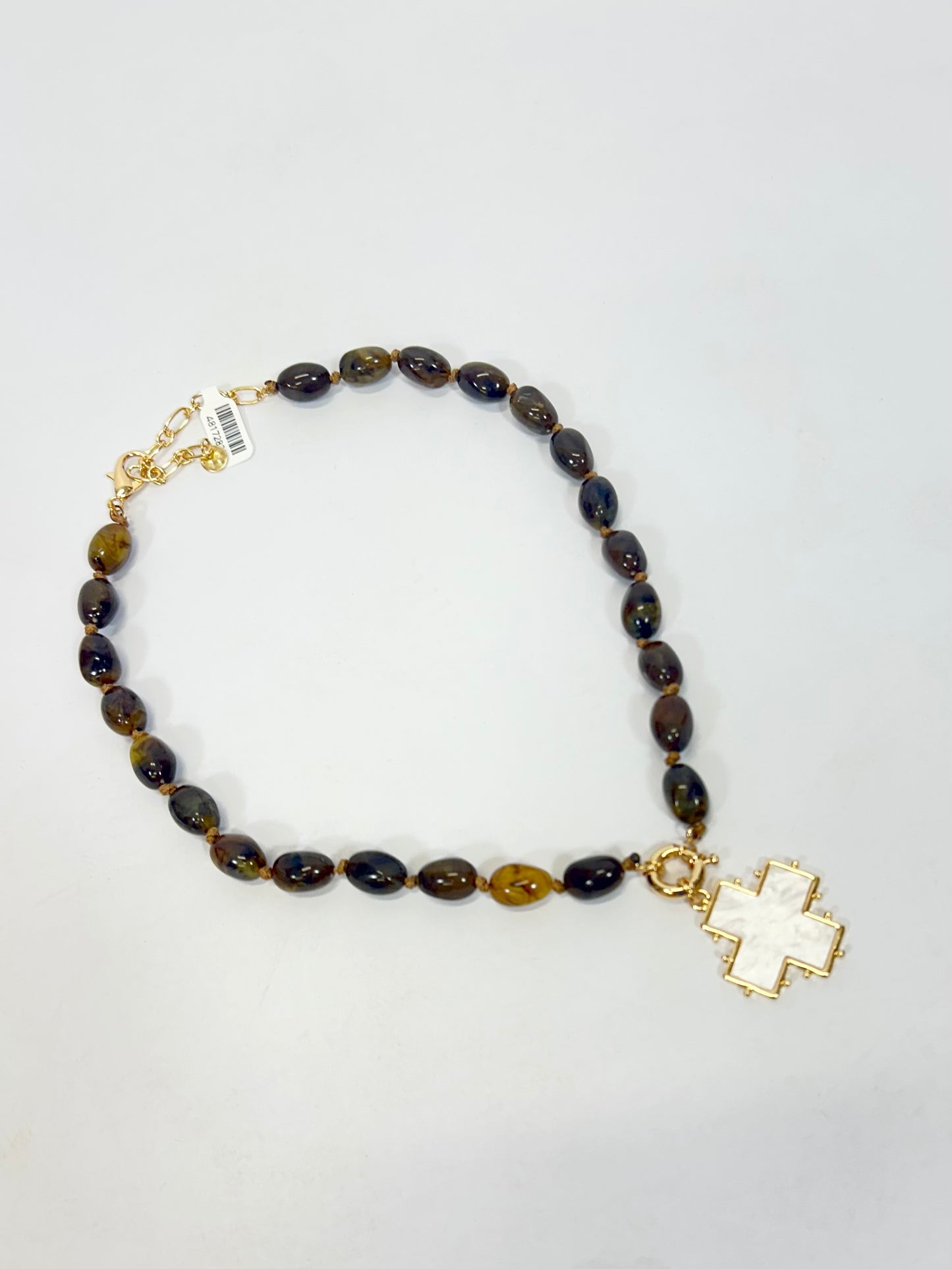 Brown acrylic oval beaded necklace with gold accents and pearlized white cross pendant charm.