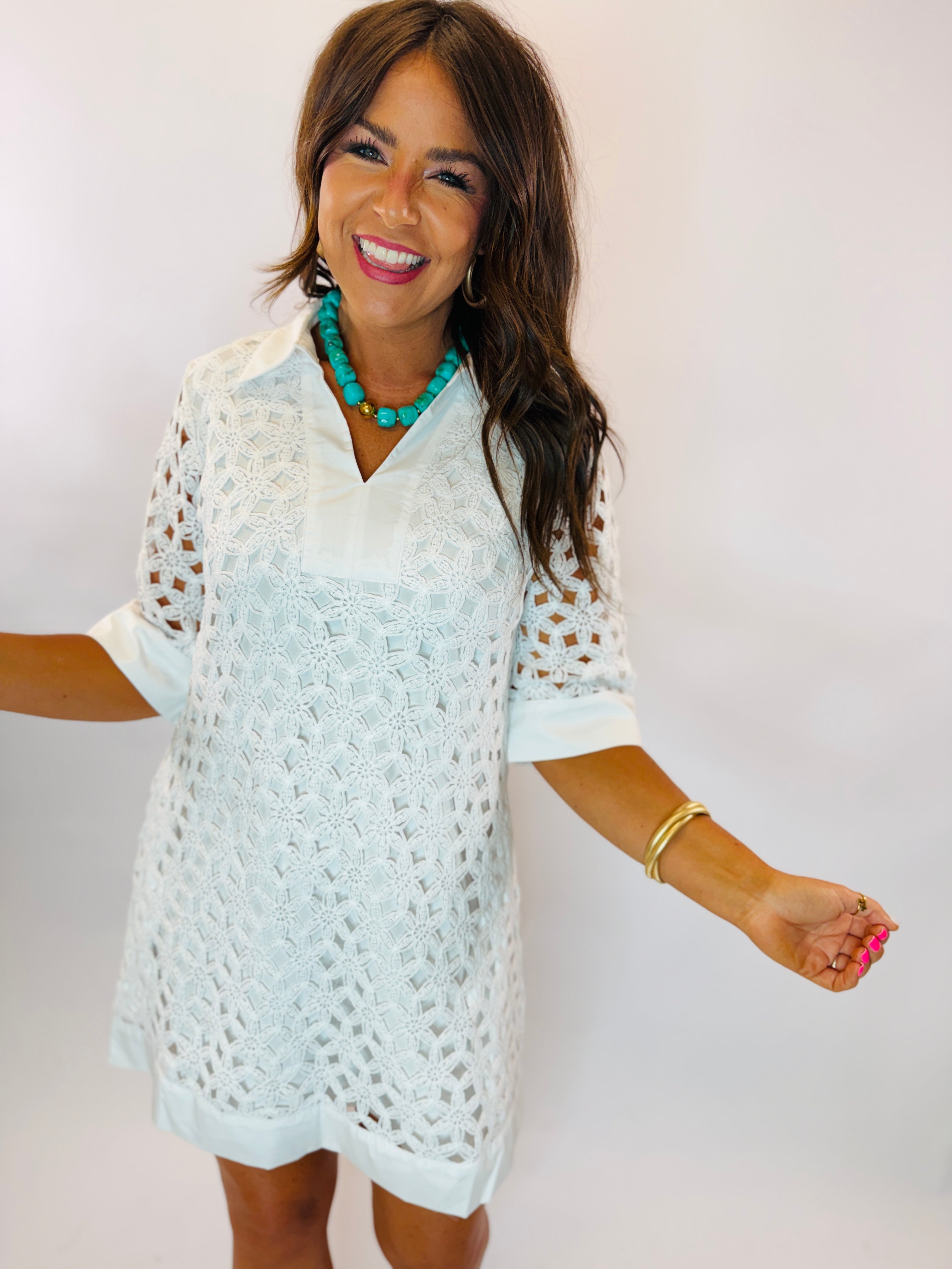 White eyelet lace short-sleeve shift dress with collar, modeled with turquoise beaded necklace.