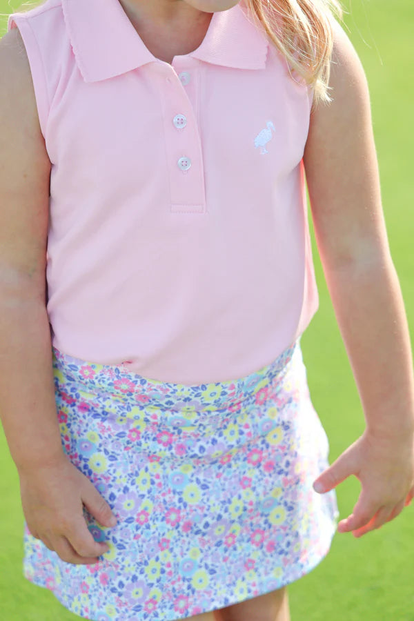 Baby wearing pink sleeveless polo top and colorful floral print Prepletic Cindy skort on green background.