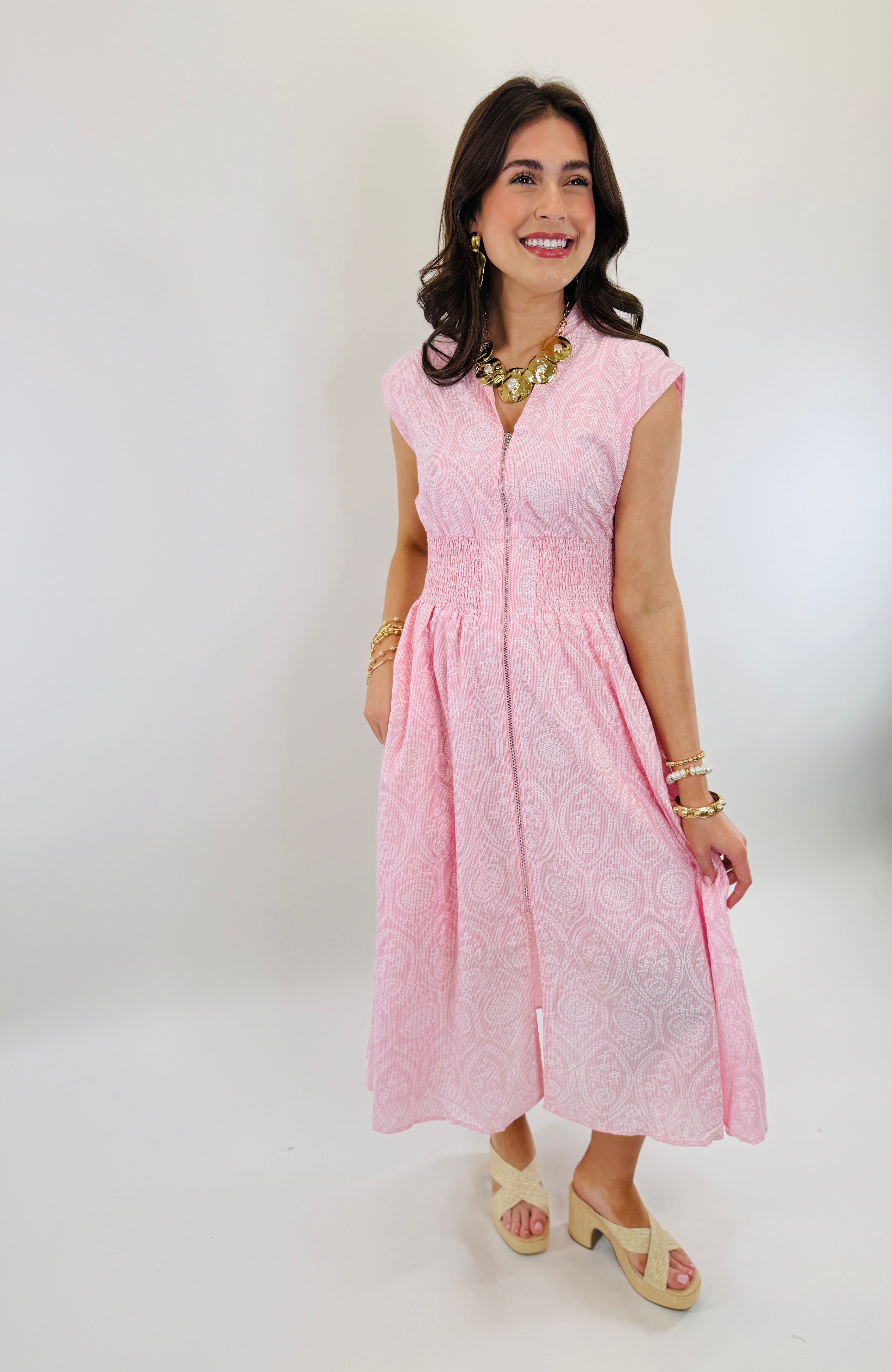 Woman wearing pink paisley patterned Kristine midi dress with cap sleeves and smocked waist detail