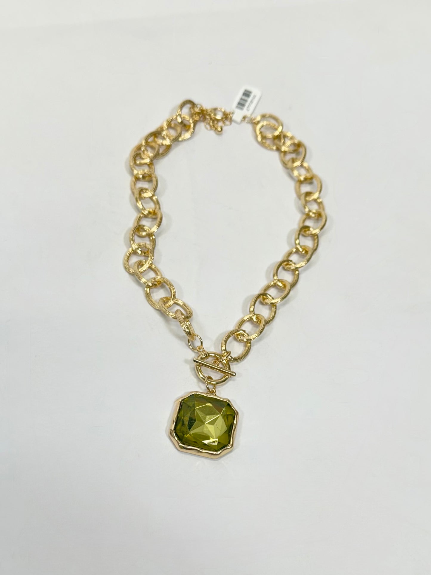 Gold chunky chain-link necklace with large faceted green square stone pendant and toggle clasp.