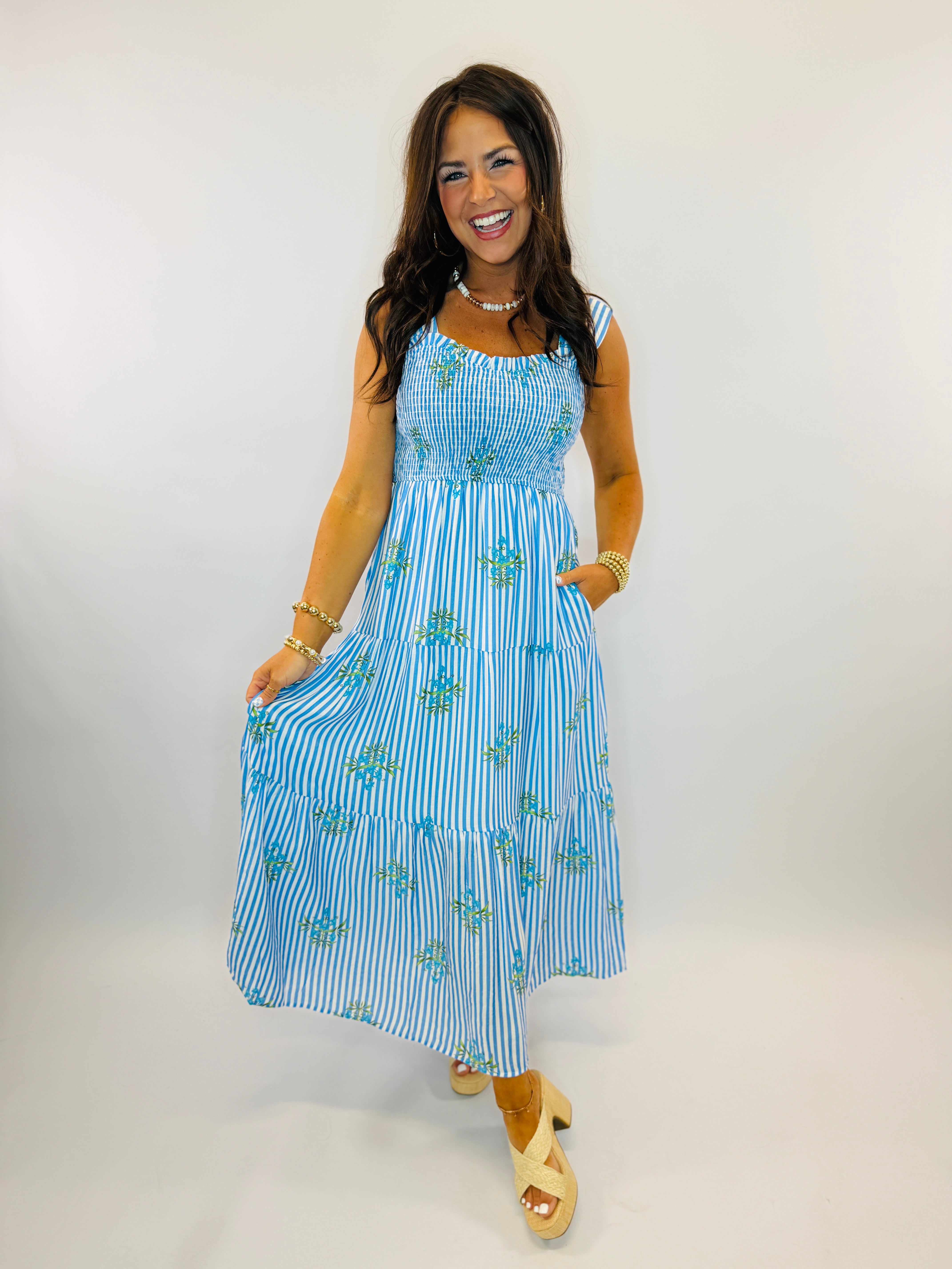 Blue and white striped maxi dress with floral embroidery, sleeveless design, and tiered skirt