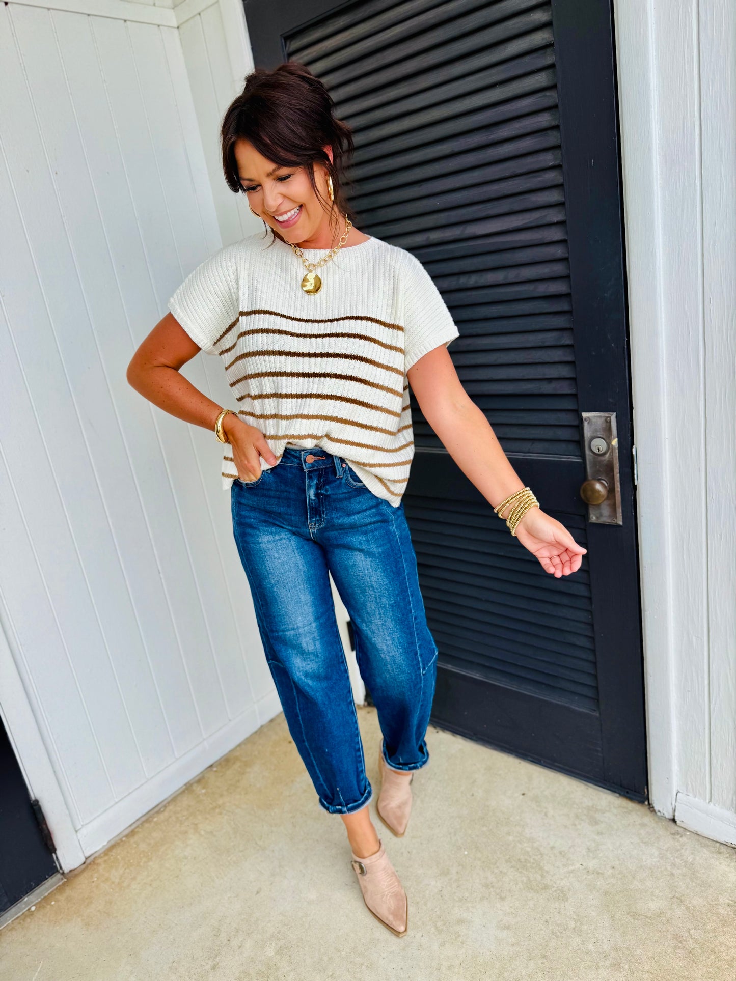 Woman wearing blue barrel-leg denim jeans with striped sweater and nude heels in casual outfit styling.