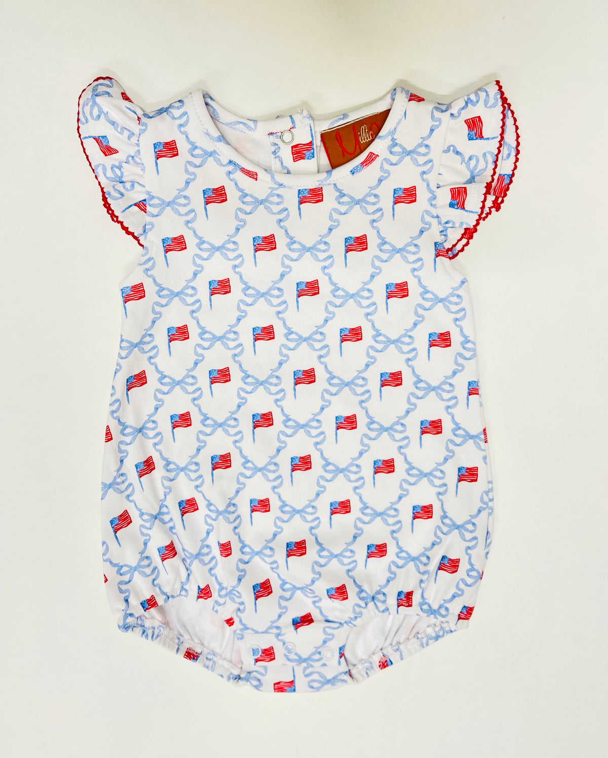 White baby bubble romper with blue ribbon bows and red American flag pattern, featuring flutter sleeves with red trim.