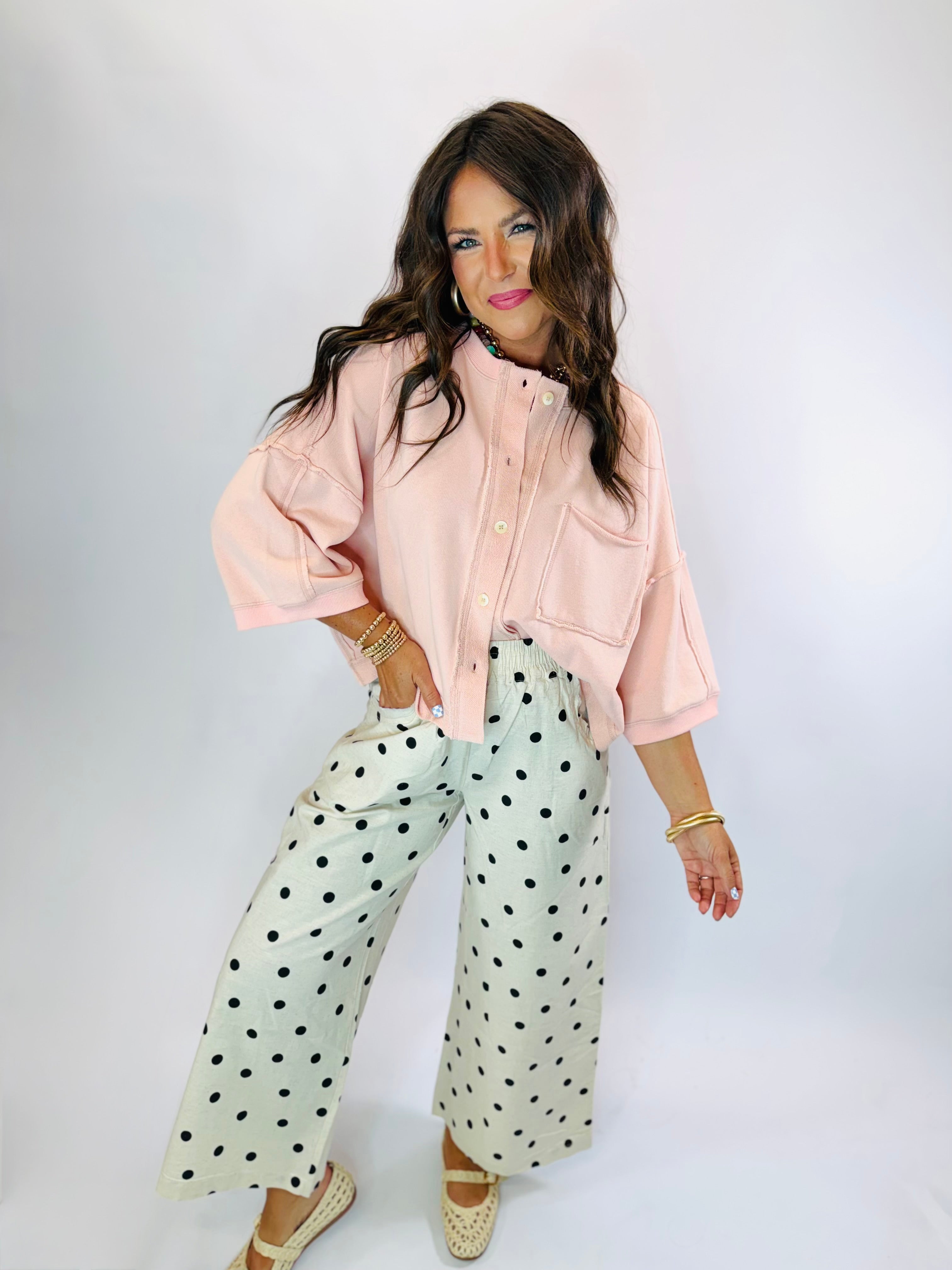 Oversized pink button-down crop top with short sleeves and front chest pocket.