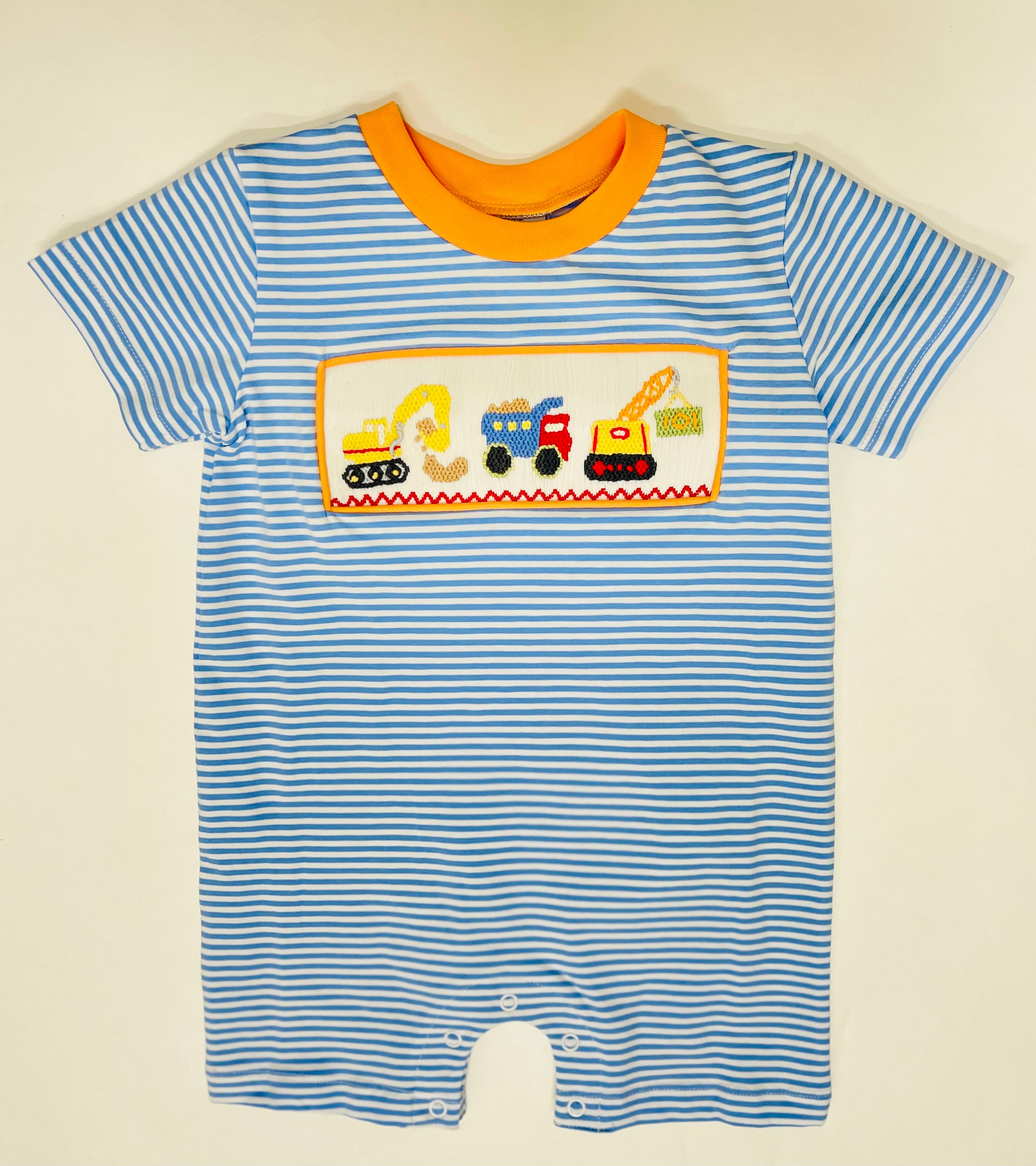 Blue and white striped baby romper with orange trim and embroidered construction vehicles design.