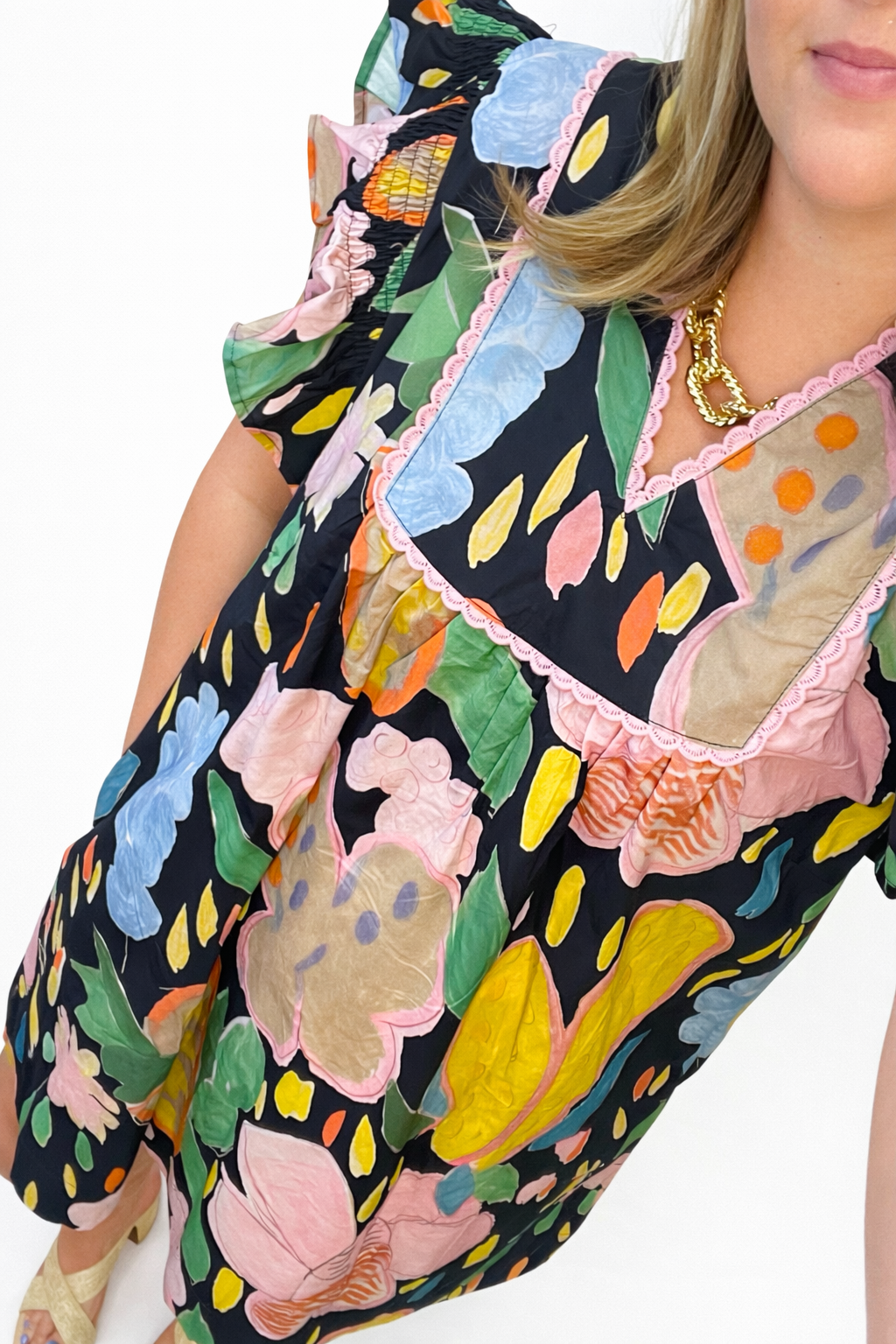 Colorful floral print dress with ruffle details, long sleeves, and mixed pattern design on black background.