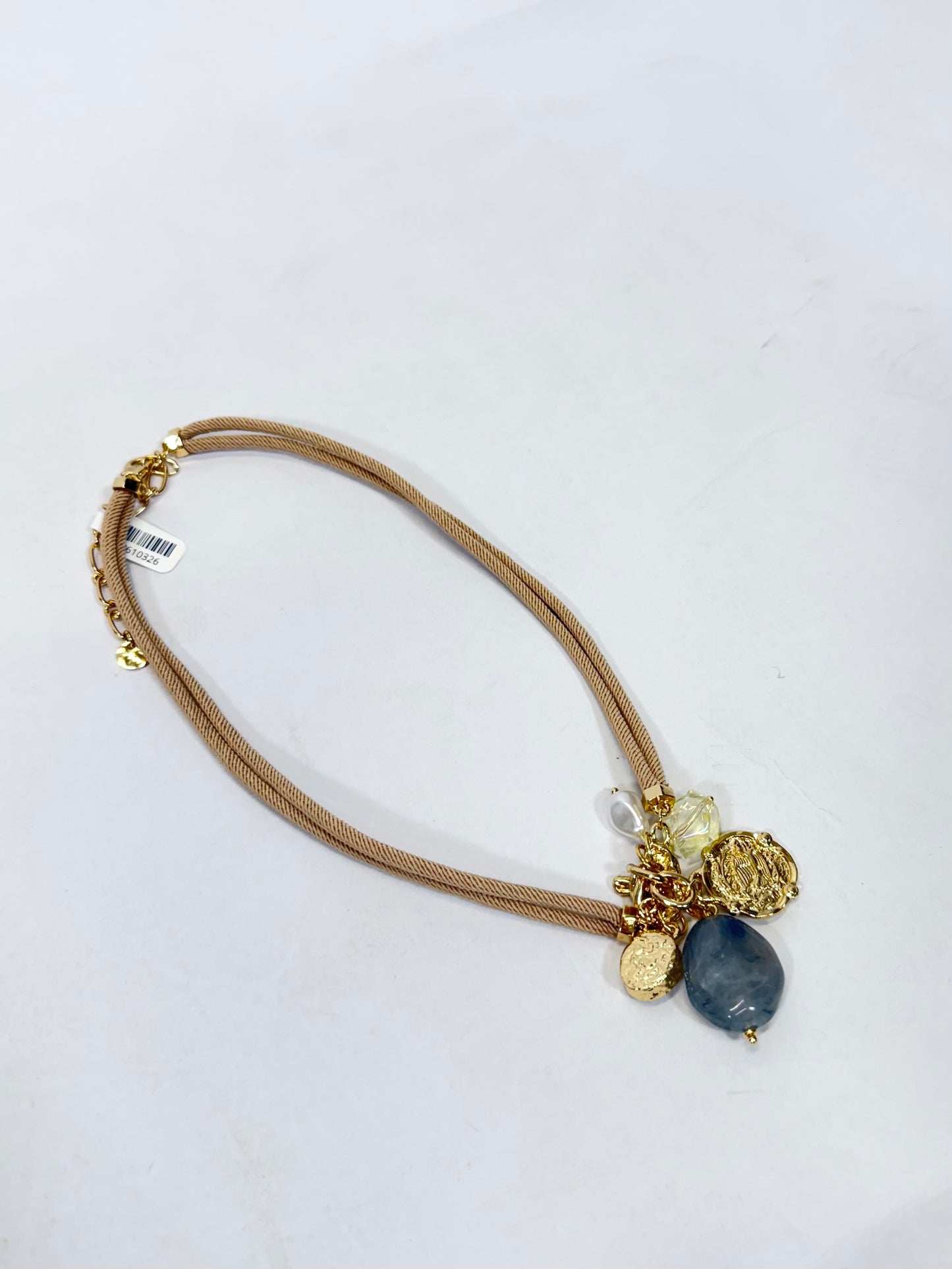 Tan cord necklace with gold charms, blue stone pendant, and crystal accents, 16–18 inches.