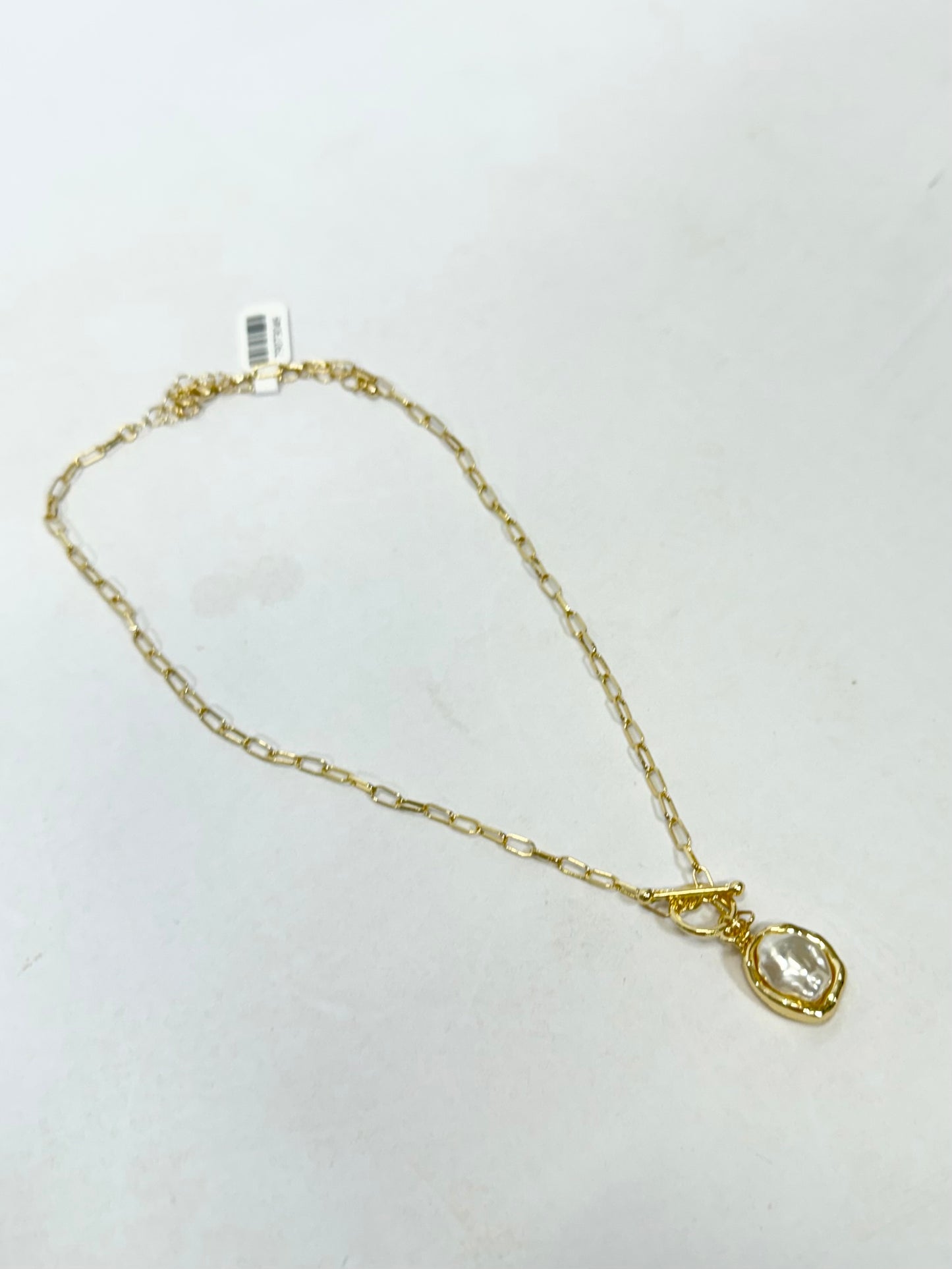 Gold paperclip chain necklace with freshwater pearl pendant in gold bezel setting and toggle clasp.