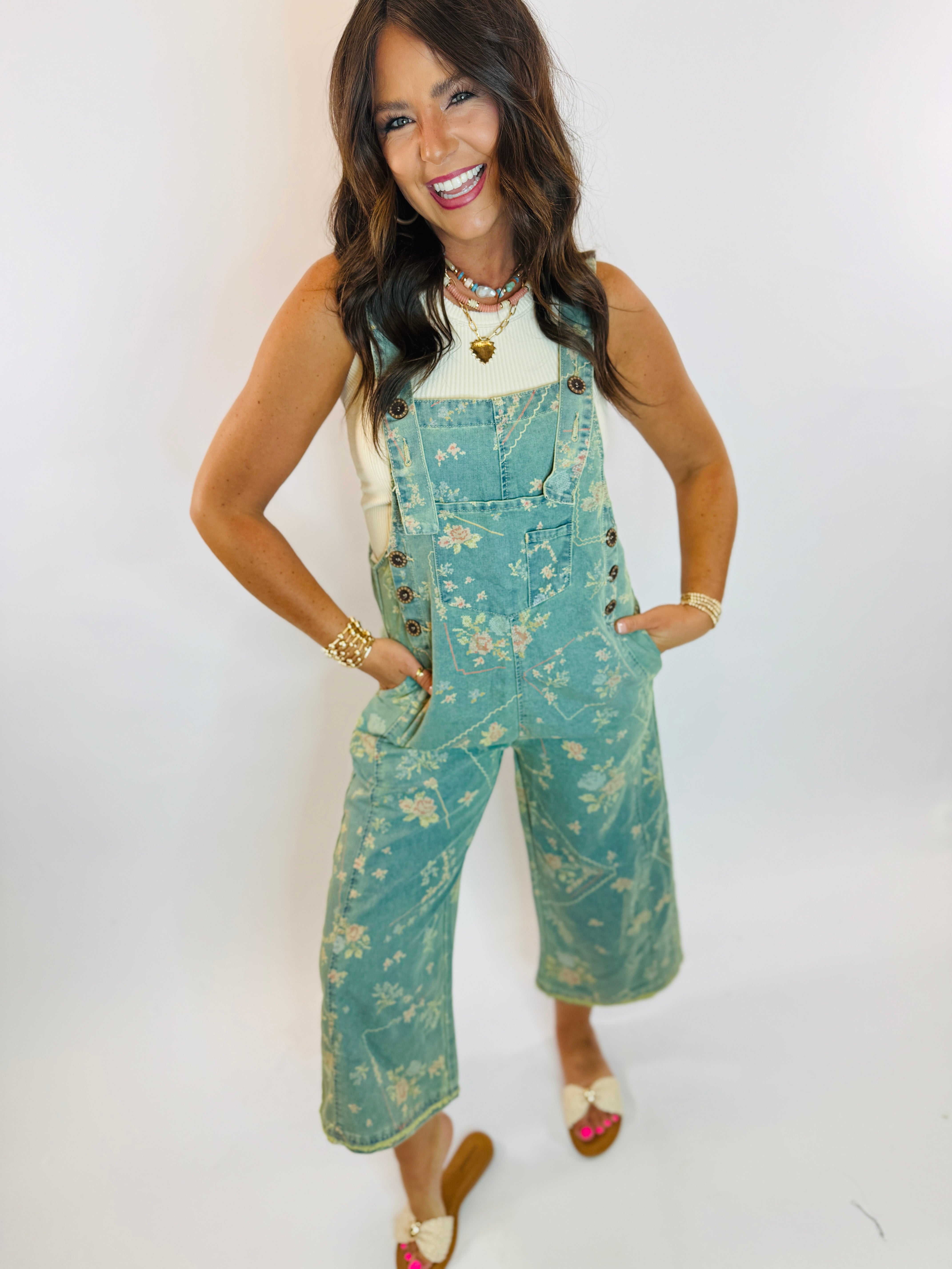 Maisie floral-print teal denim wide-leg cropped overalls styled with white tank top and sandals.