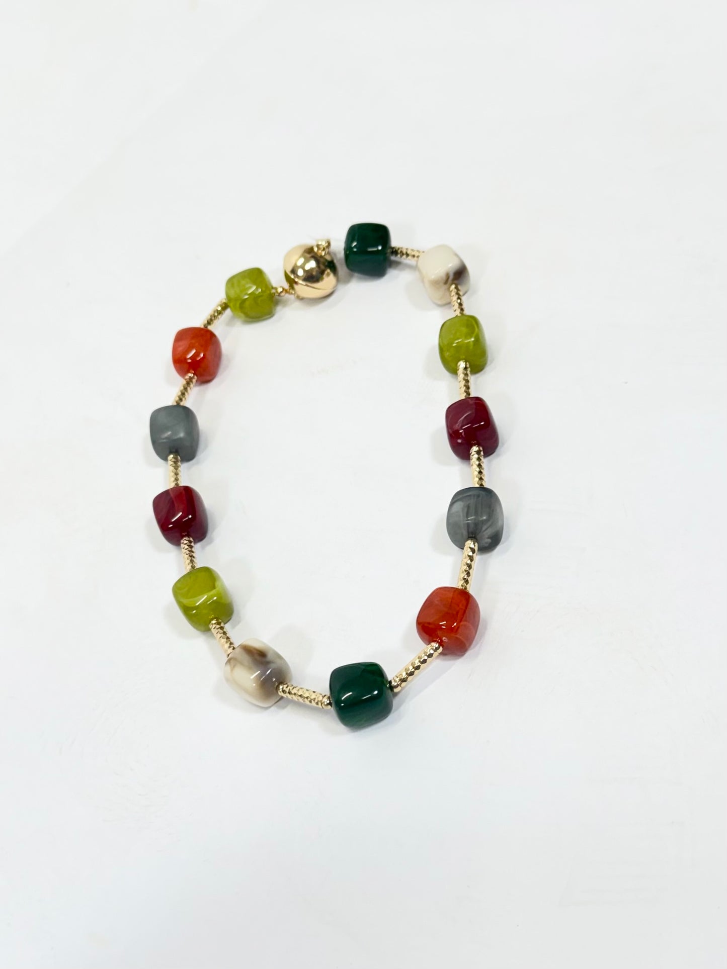 Multicolored cube beaded necklace with gold bar links, featuring red, green, gray, and cream stones.