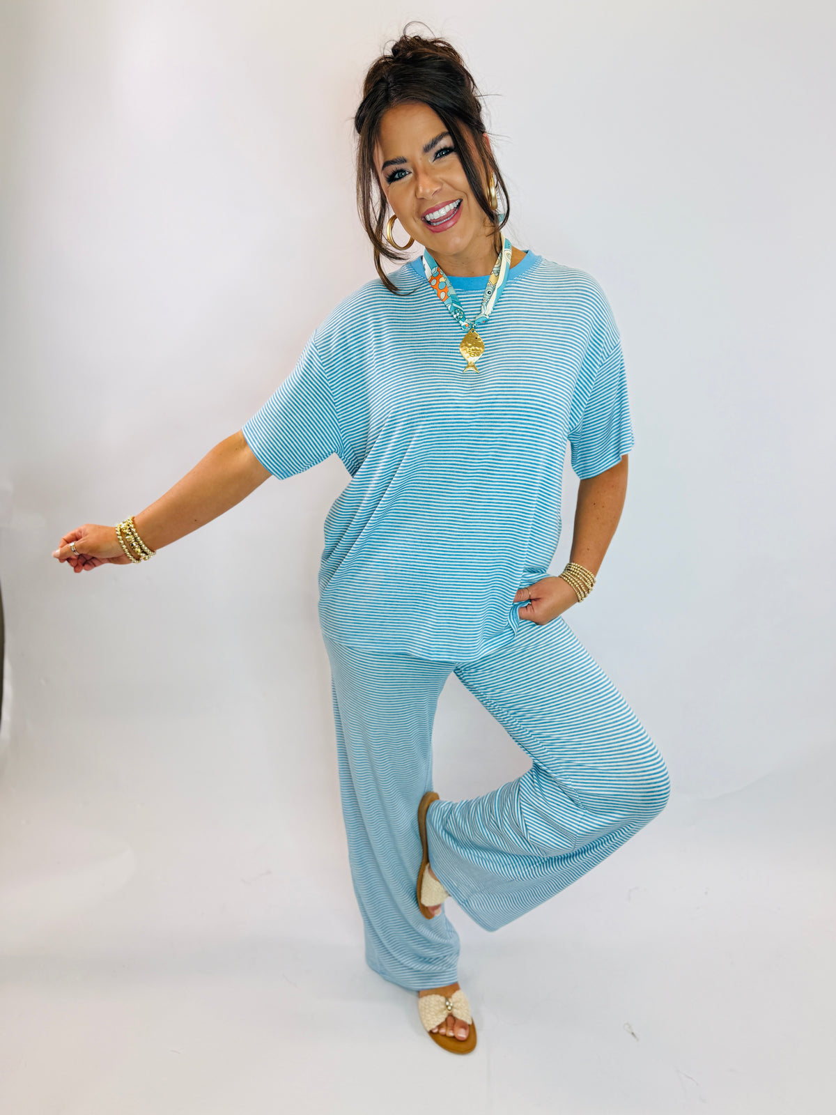 Woman wearing blue striped two-piece loungewear set with short-sleeve top and matching pants