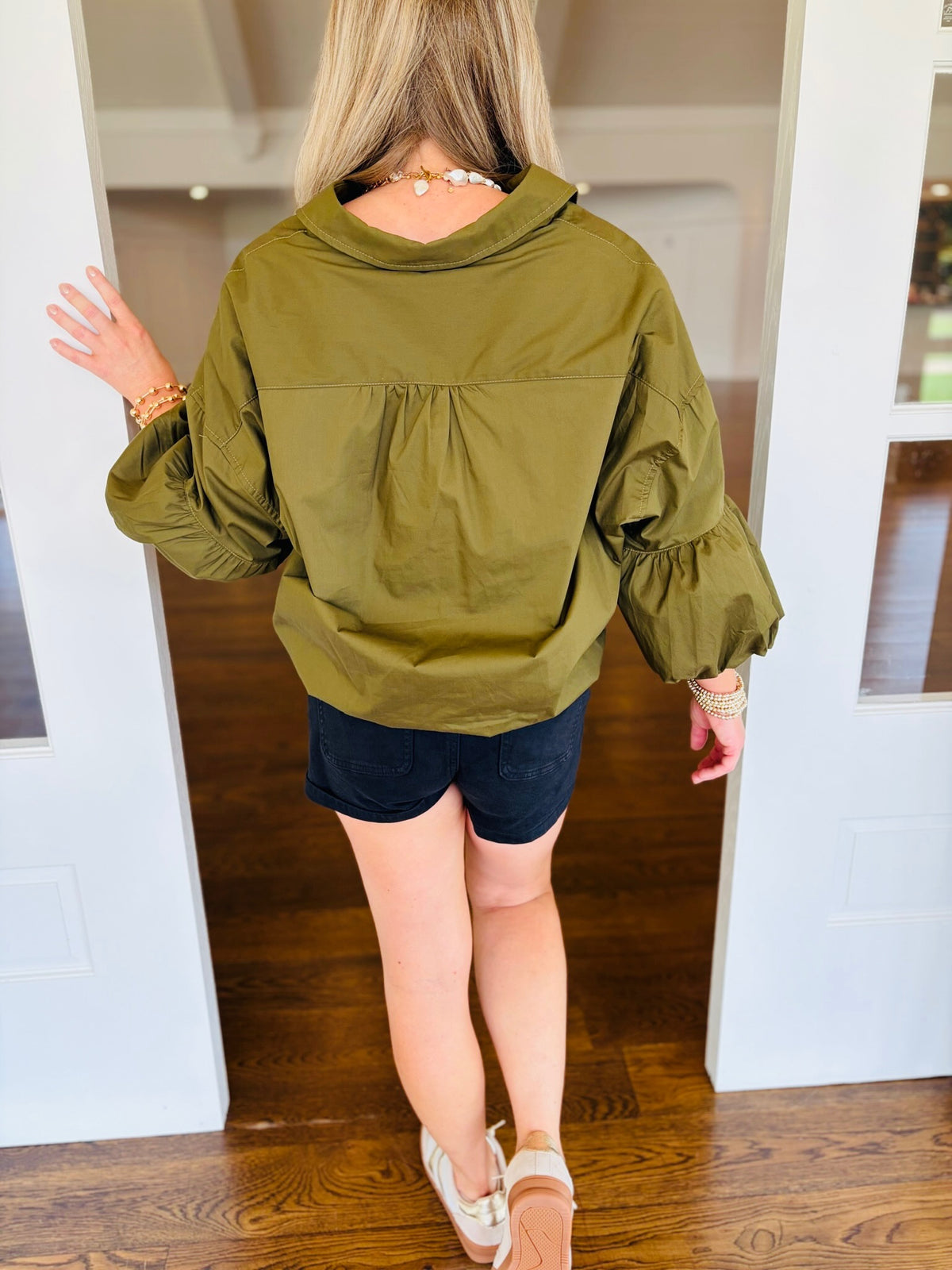 Back view of the Ashley ash olive blouse, showing the collar, gathered back detailing, and balloon sleeves.