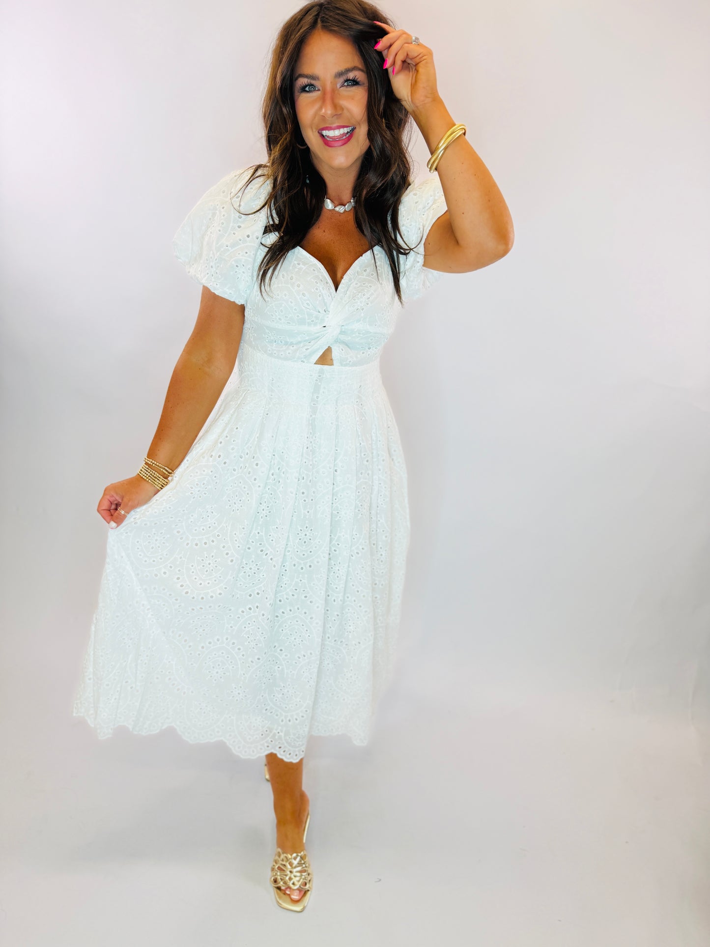 White eyelet midi dress with puff sleeves, sweetheart neckline, cutout detail, and scalloped hem.