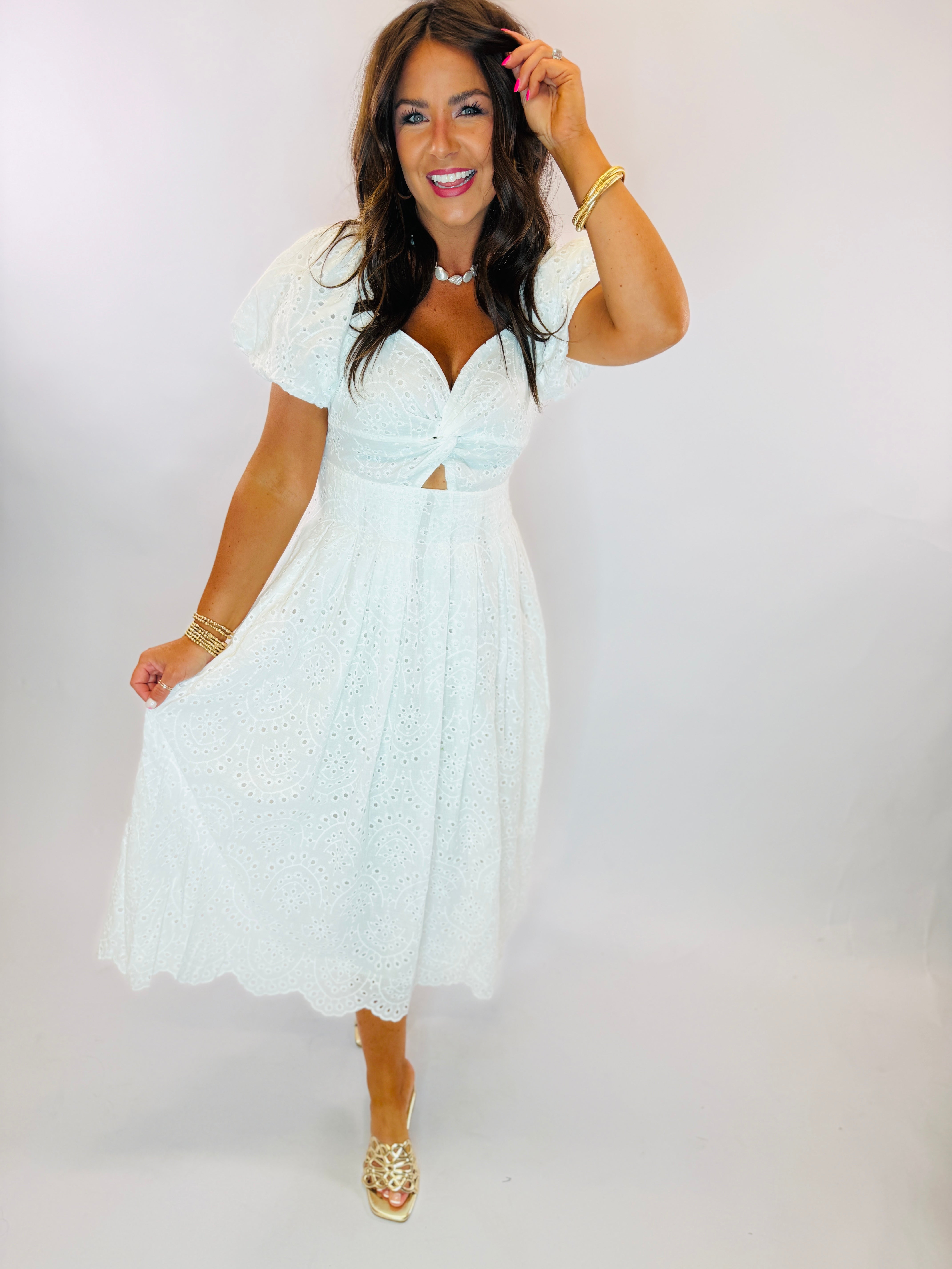 White eyelet midi dress with puff sleeves, sweetheart neckline, cutout detail, and scalloped hem.