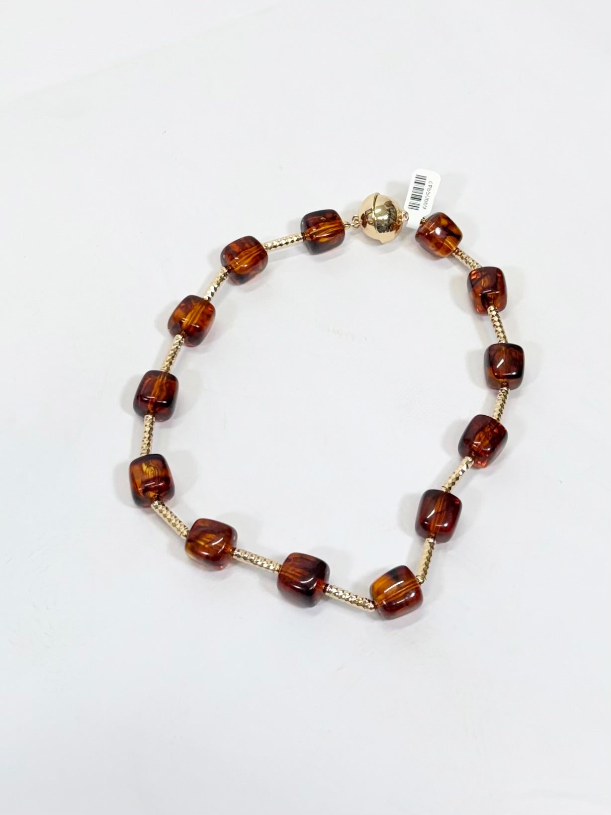Brown translucent cube beads alternating with gold textured bar spacers on an 18-inch necklace with gold clasp.