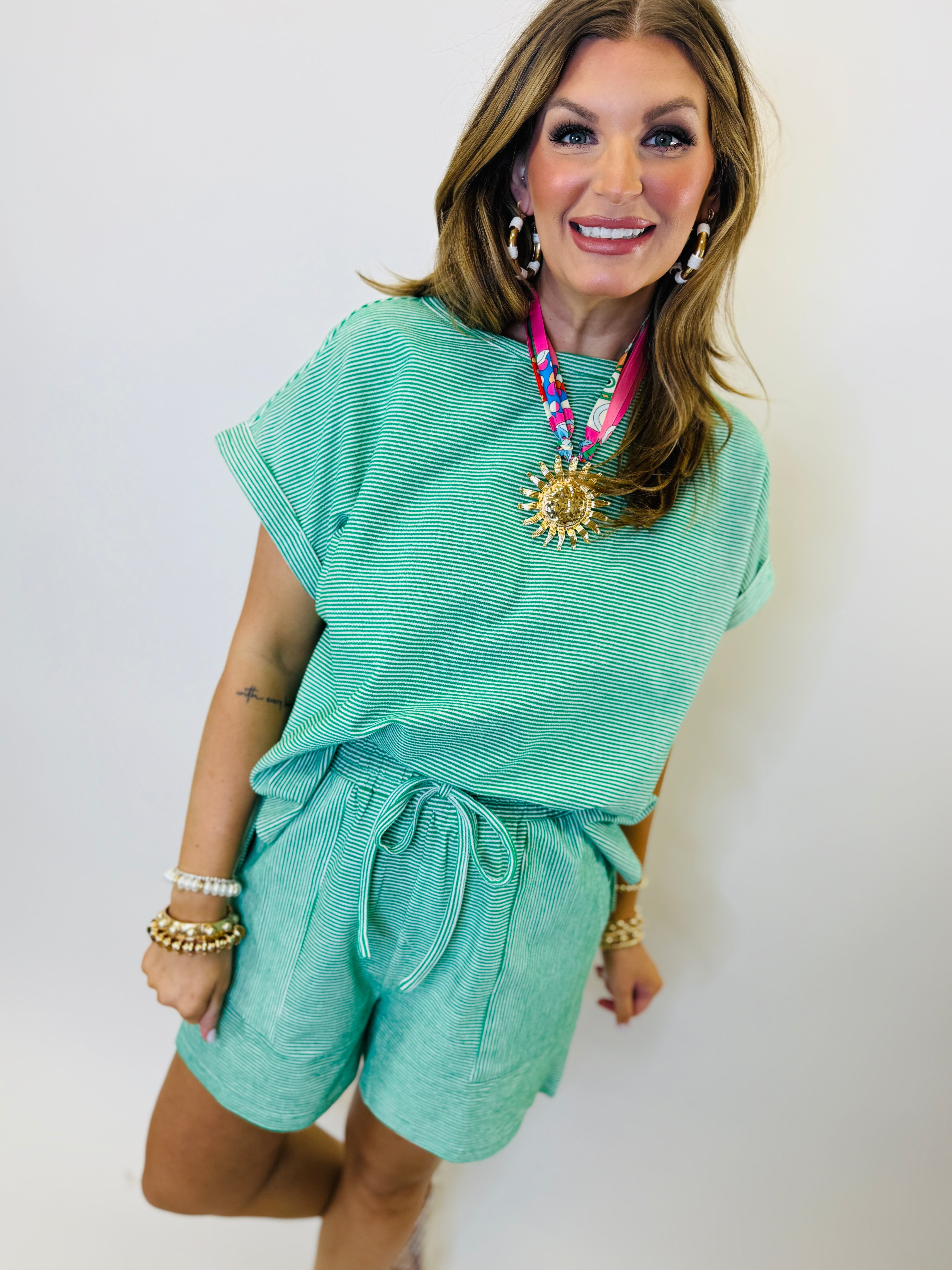 Woman wearing mint green striped two-piece set with short-sleeve top and drawstring shorts