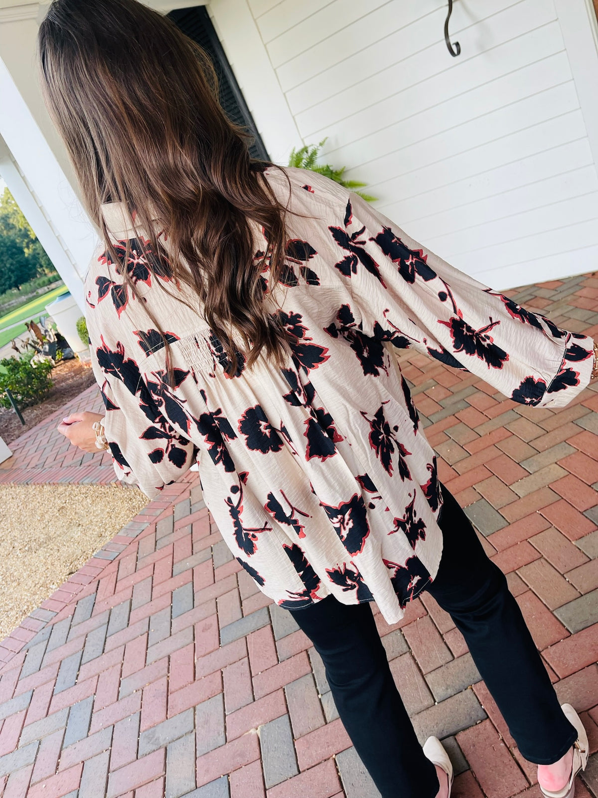 Back view of the Cora ecru and black floral tie neck blouse, showing gathered back detailing and long sleeves.
