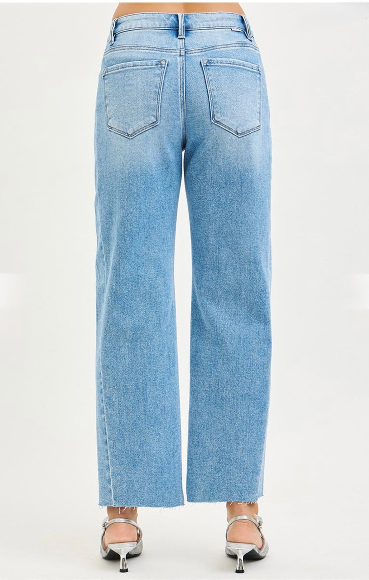 Light blue wide-leg barrel jeans with raw hem, shown from back view with heeled sandals.