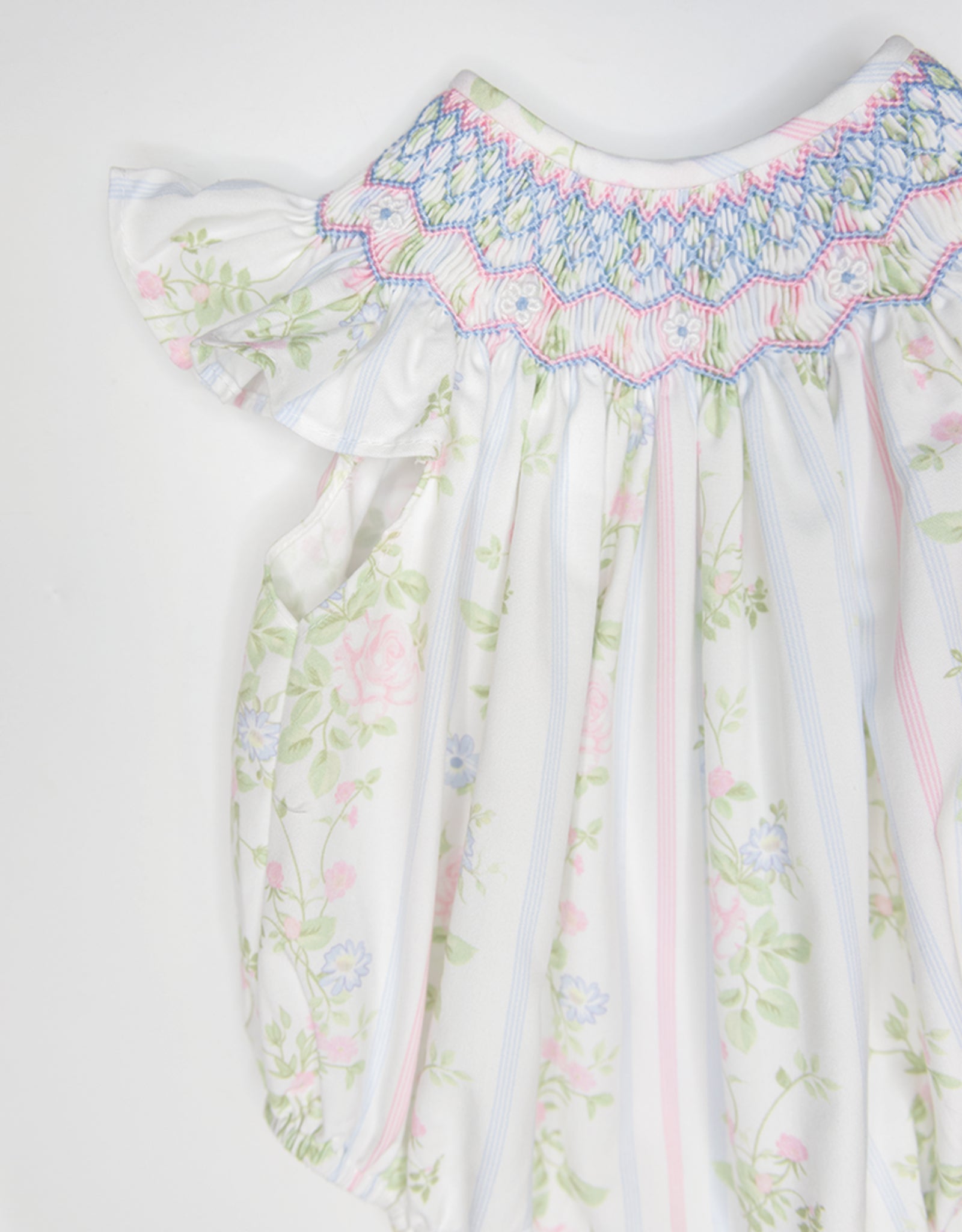 White baby bubble romper with pink and green floral print and multicolored smocked neckline detail