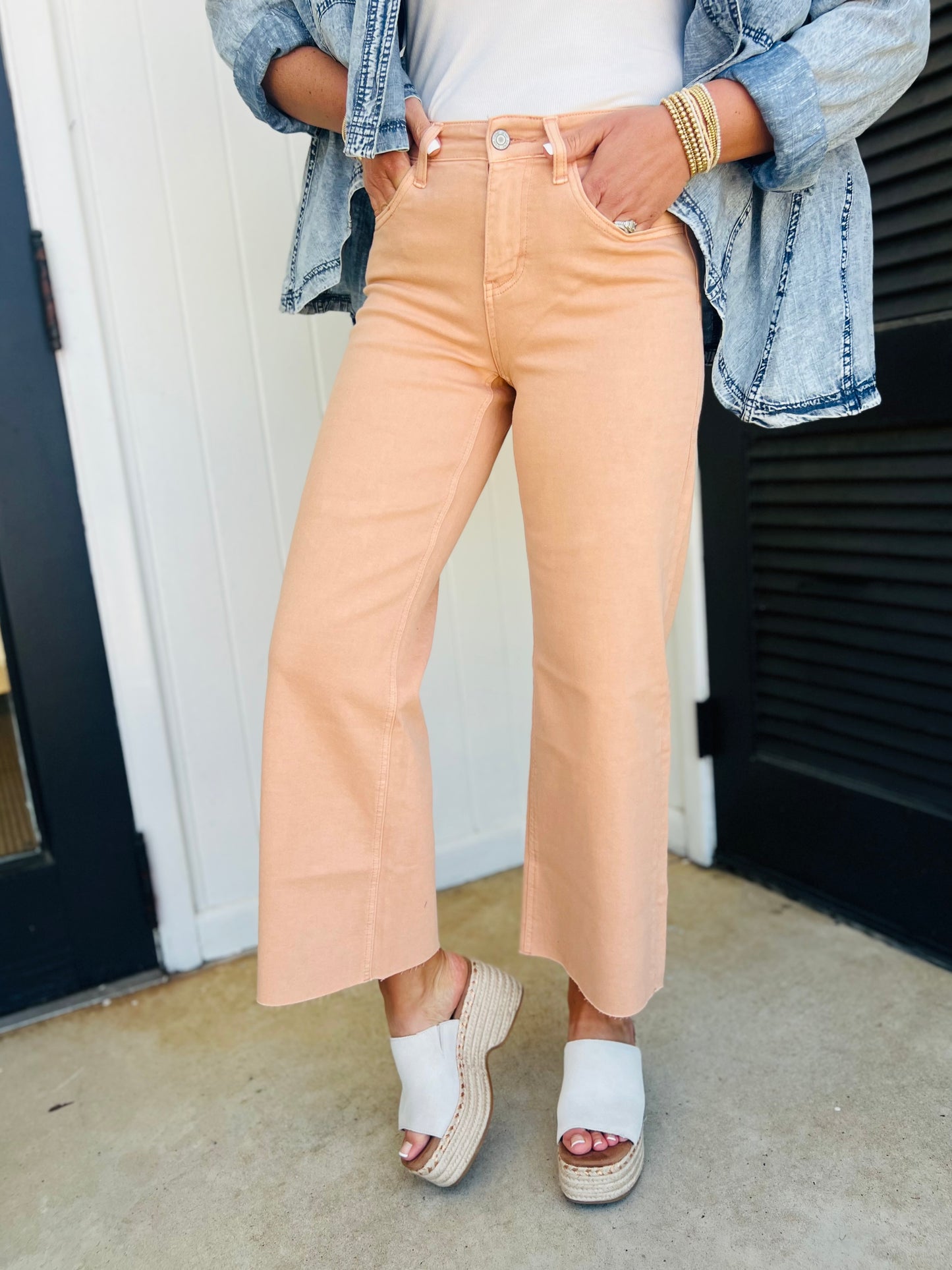 Woman wearing sandy beige wide-leg cropped denim jeans with denim jacket and white platform sandals
