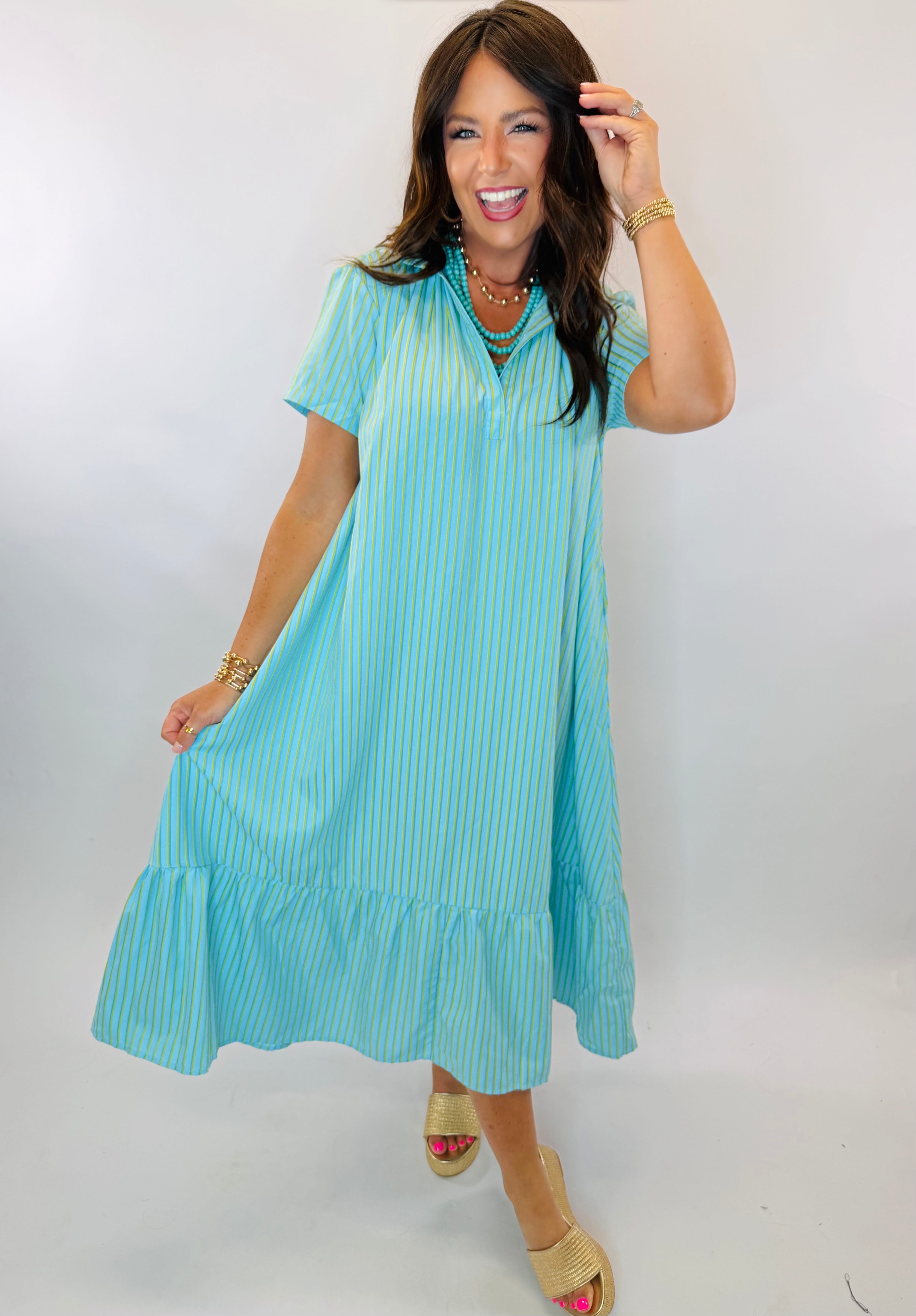 Woman wearing Kate Midi Dress in aqua blue with yellow pinstripes, short sleeves, and ruffled hem.