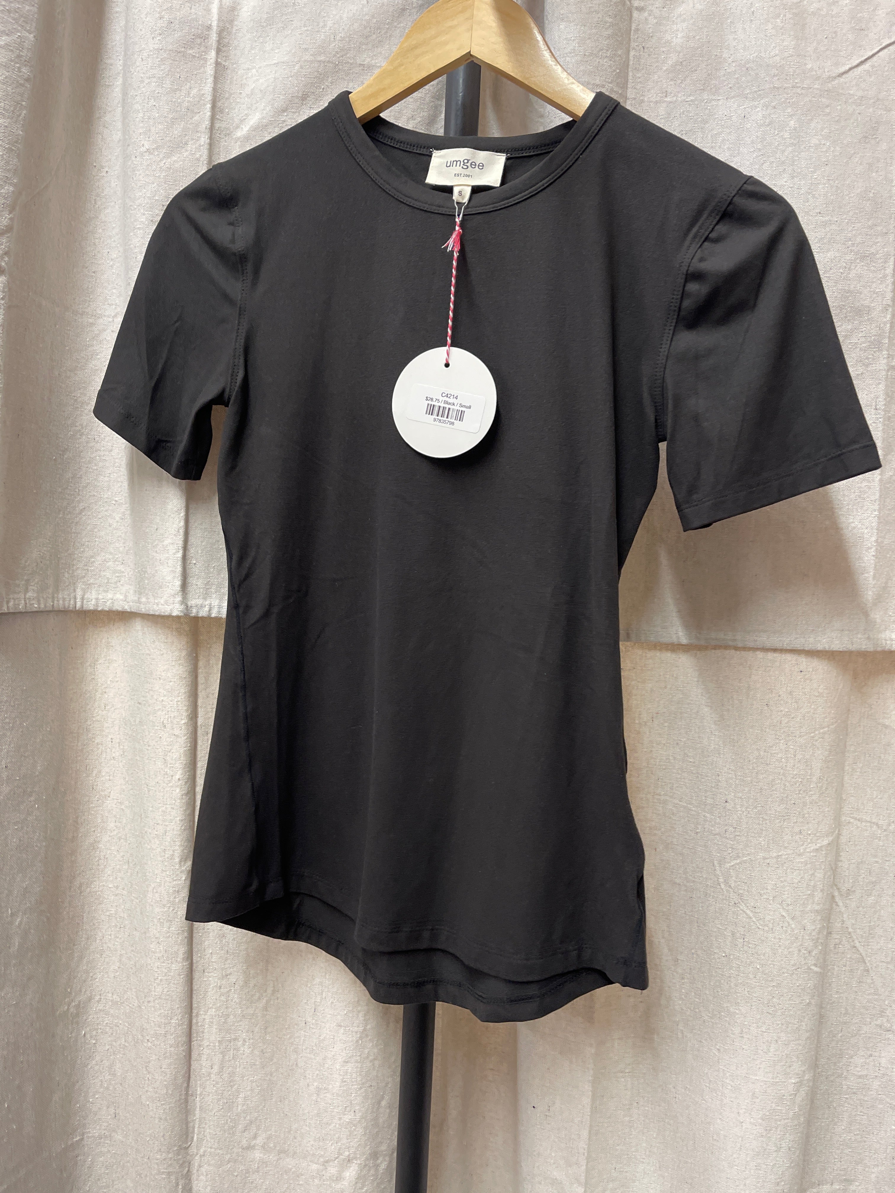 Black short-sleeve Jenny top hanging on wooden hanger with white price tag attached