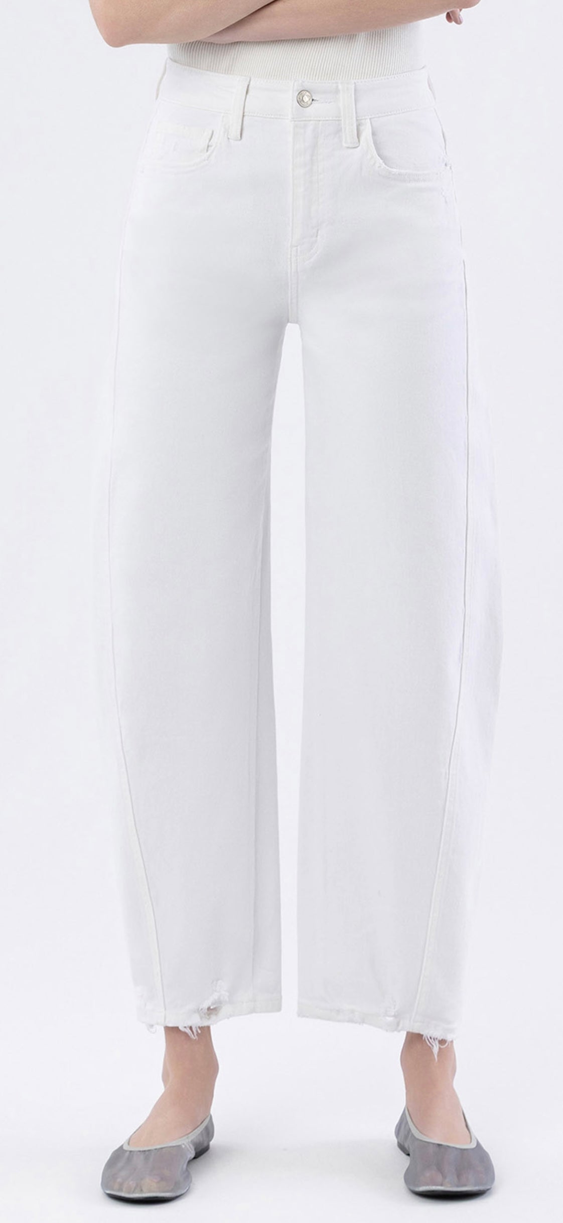 White high-waisted barrel jeans with frayed hem worn with gray ballet flats