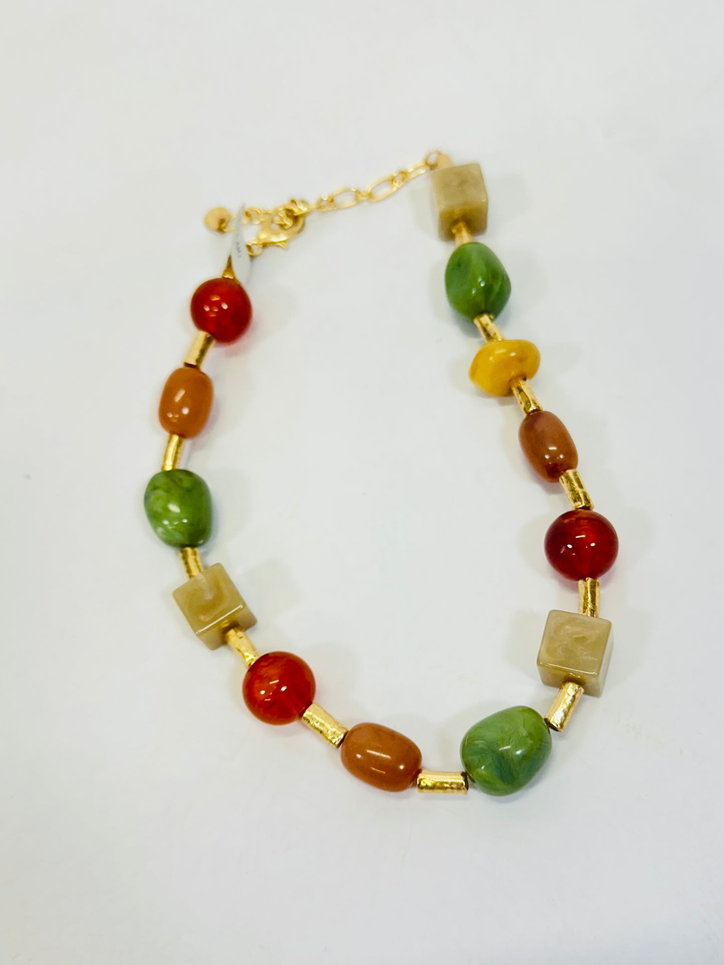 Multicolor beaded necklace featuring green, red, orange, and natural stone beads with gold tube accents.