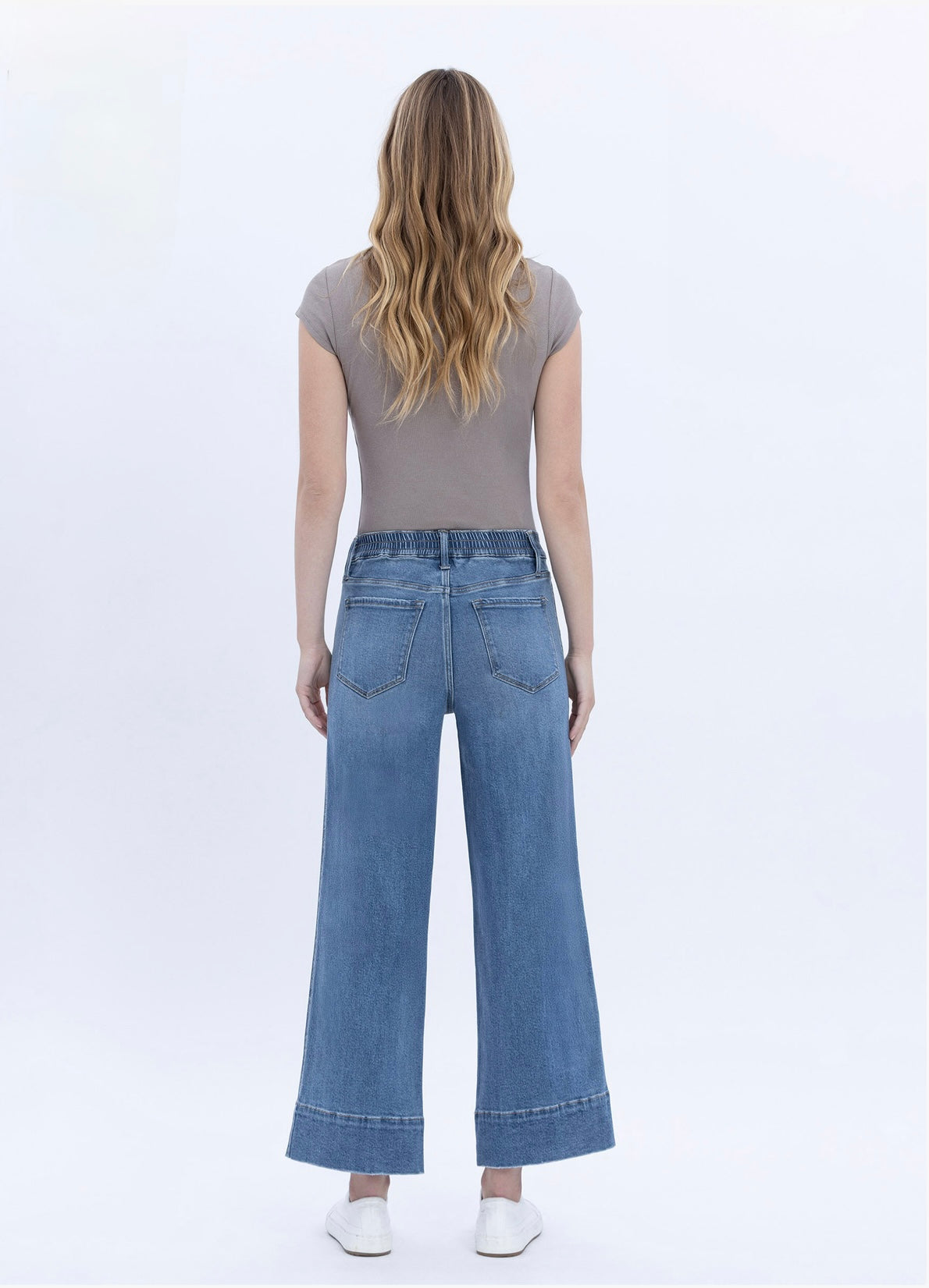Woman wearing Lainey Elastic Denim wide-leg jeans with elastic waistband and cuffed hem, shown from behind.