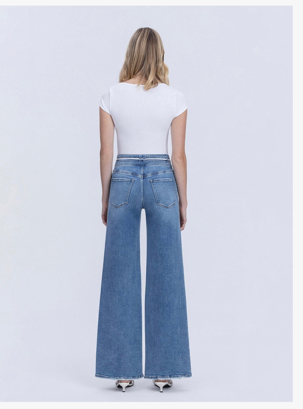 Woman wearing Bailey Drawstring Denim wide-leg jeans with white t-shirt, shown from behind on white background.