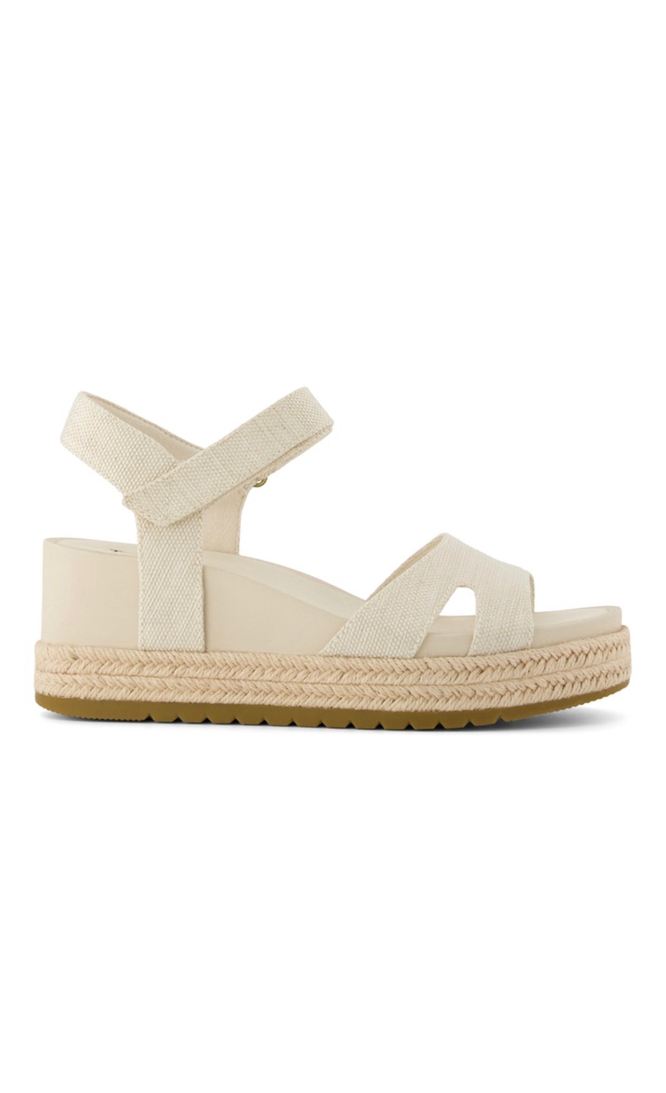 Cream colored wedge sandal with canvas straps and braided espadrille sole on white background