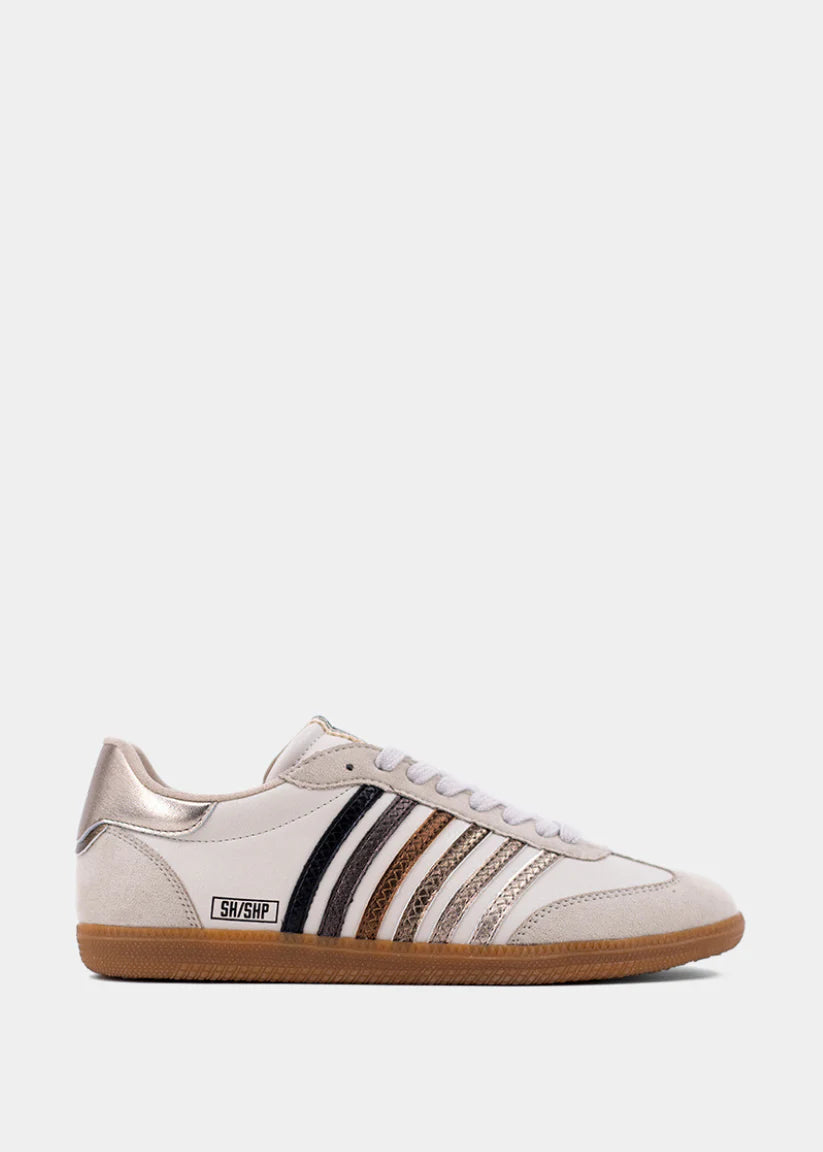 Beige Stevie Classic Sneaker with metallic stripes, white laces, and gum sole on light background