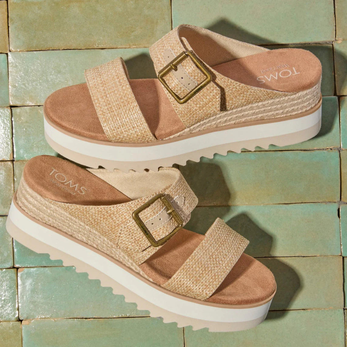 Natural woven Diana Wedge Mule sandals with buckle straps and platform soles on green tile background