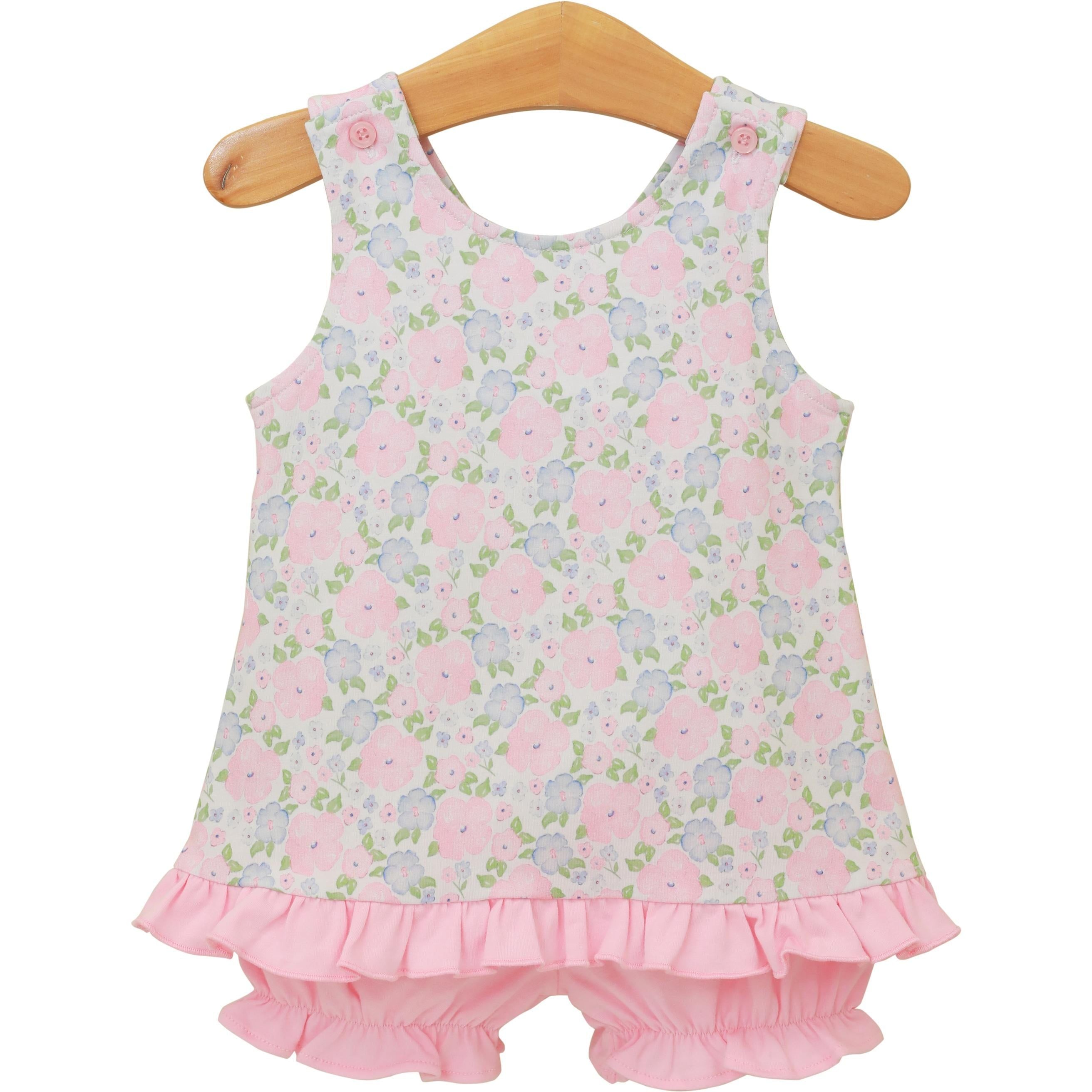 Sleeveless floral dress with pink ruffled hem and matching bloomers on wooden hanger