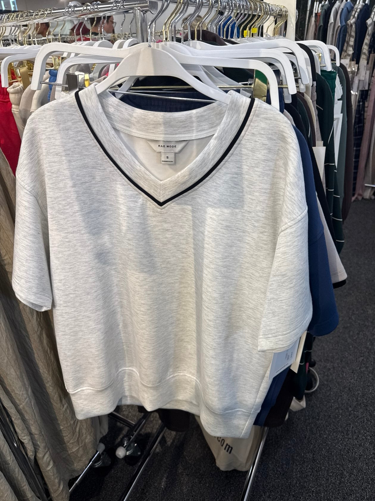 Light heather grey short-sleeve V-neck crop top with black trim detail, size small, on hanger.
